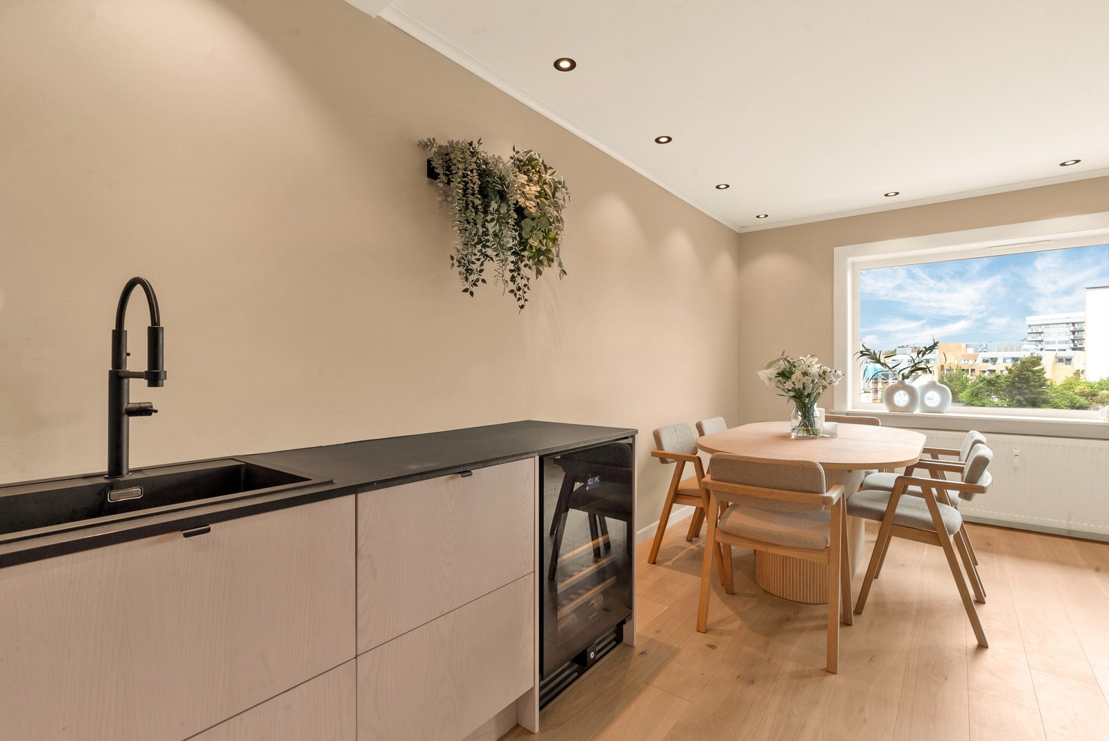 Med downlights i himlingen, slette overflater og flott gulv. Lekker kjøkkeninnredning fra 2023 med laminat benkeplate og integrerte hvitevarer som stekeovn, platetopp, oppvaskmaskin, vinskap og kombinert kjøleskap og frys. Galleribilde