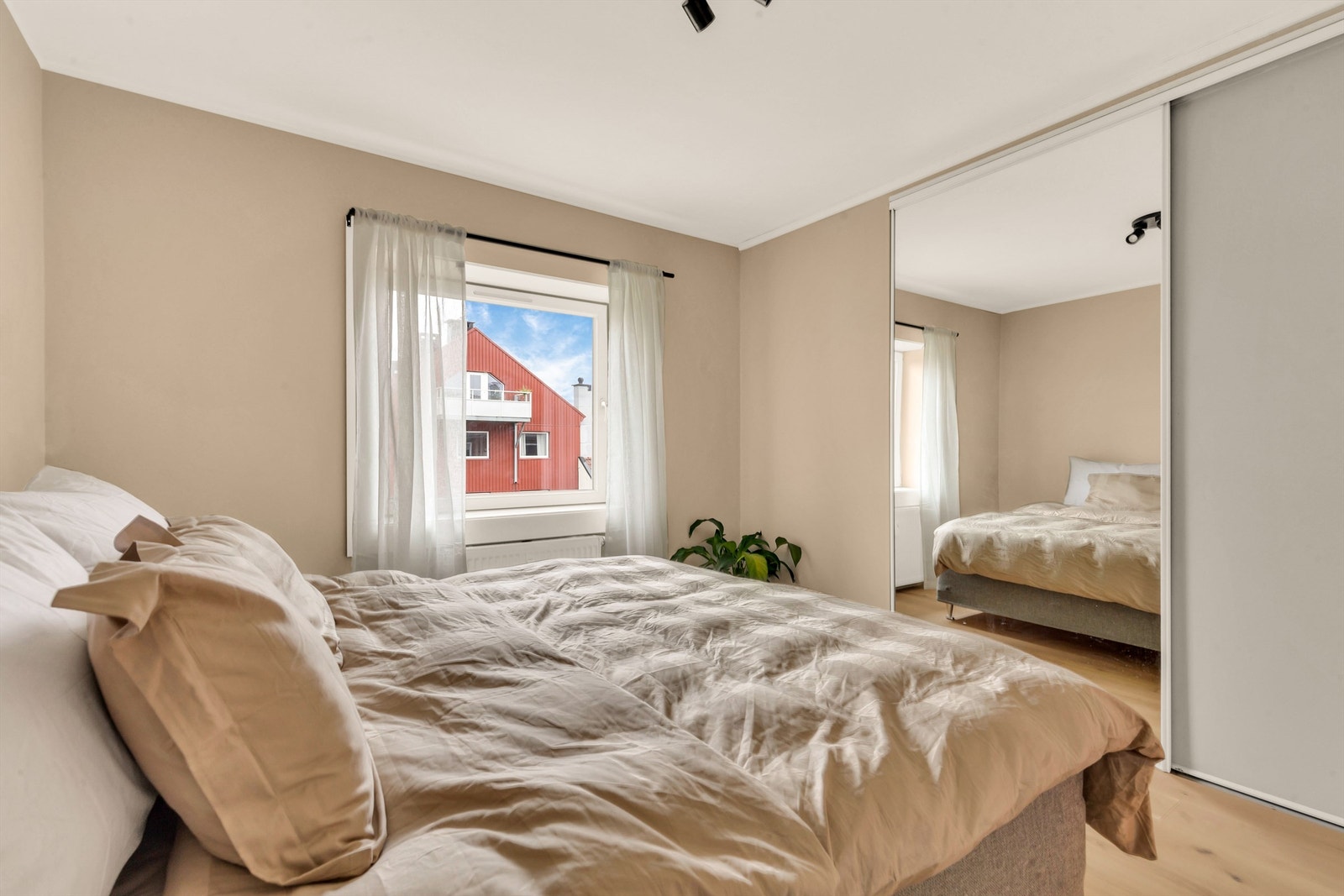 Behagelig og svalt rom med morgensol og stor skyvedørsgarderobe med speil Galleribilde