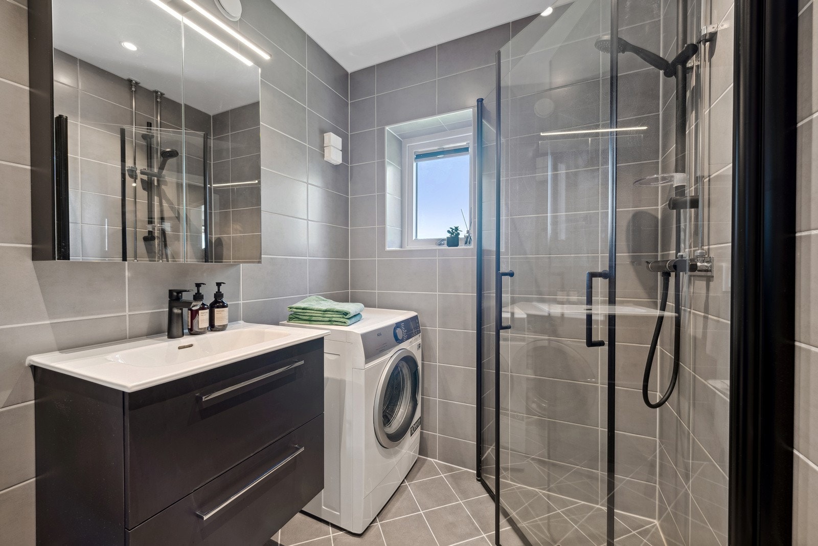 Badet er utstyrt med pen baderomsinnredning og dusj med innfellbare glassvegger. Galleribilde