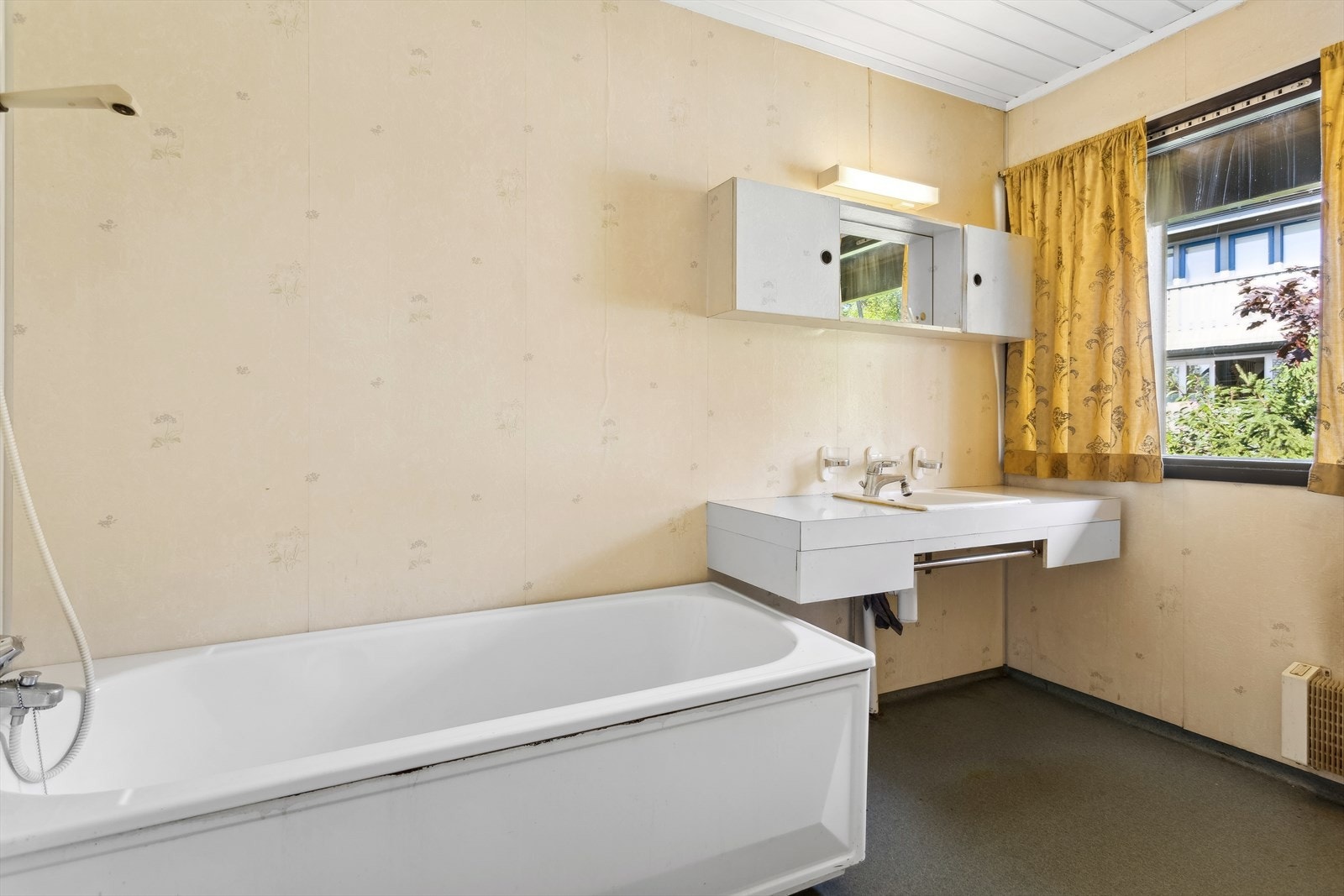 Badet er utstyrt med servant nedfelt i benkeplate, speilskap og badekar. Galleribilde