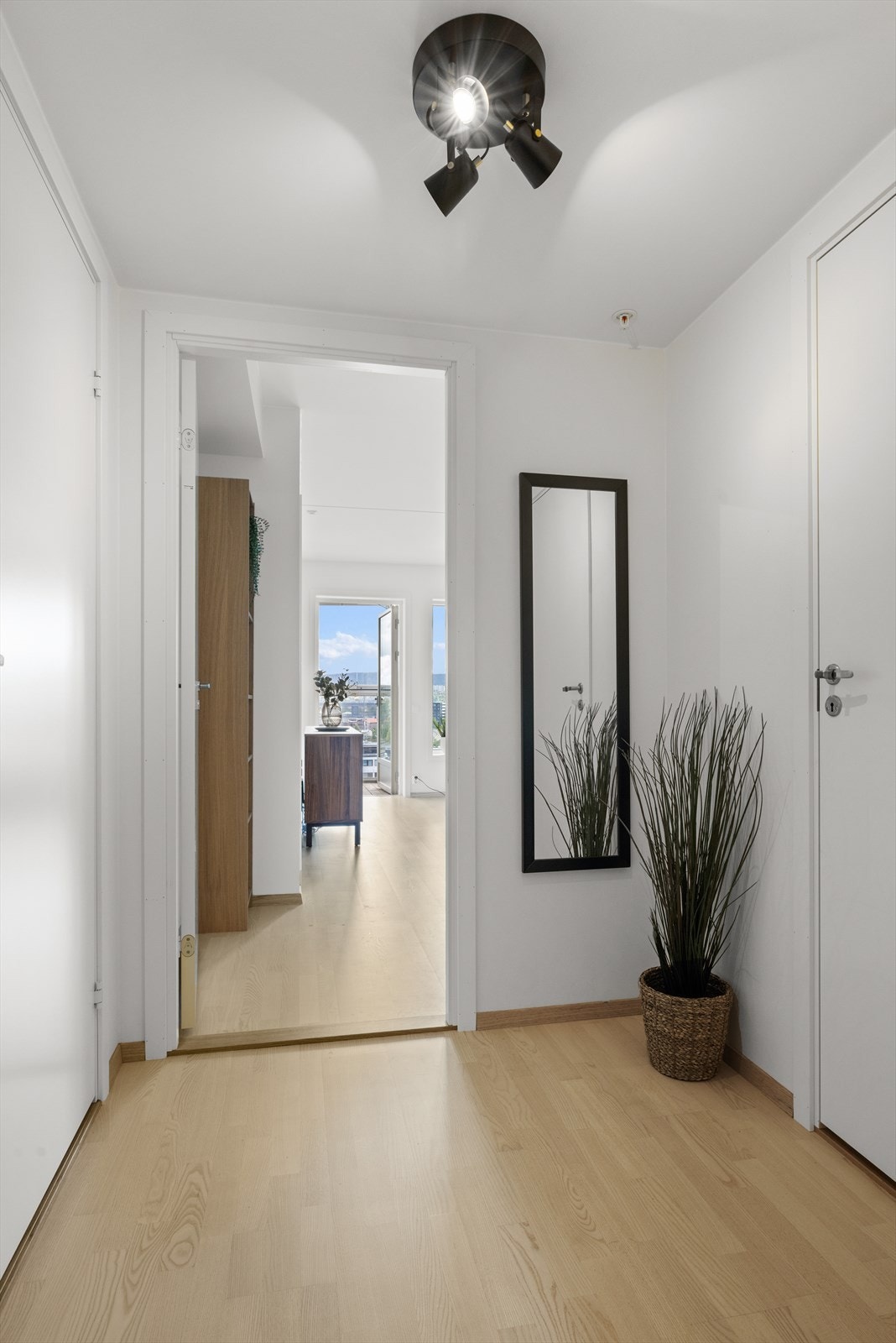Innbydende entré med plass til oppheng av tøy og oppbevaring av sko. Parkett på gulv. Galleribilde