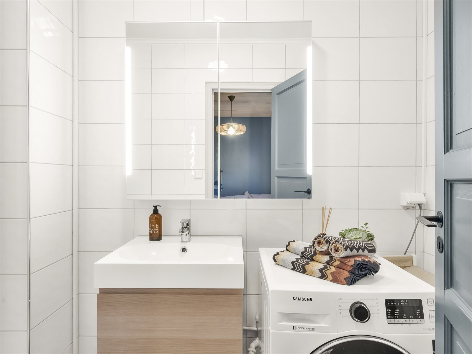 Effektiv baderomsinnredning med vaskemaskin og speilskap. Galleribilde