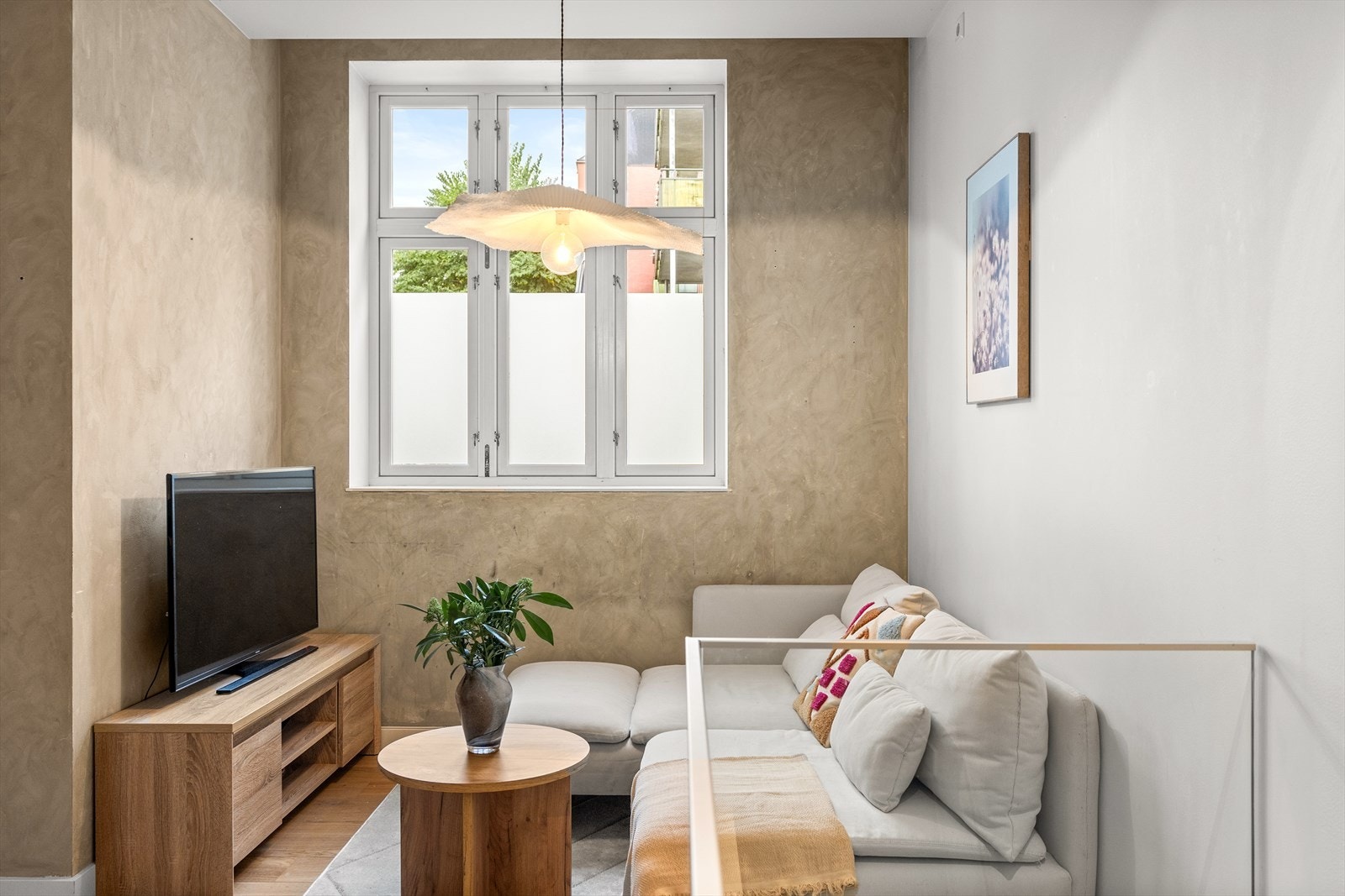 Et stort vindu slipper inn rikelig med naturlig lys, noe som forsterker de lyse overflatene Galleribilde