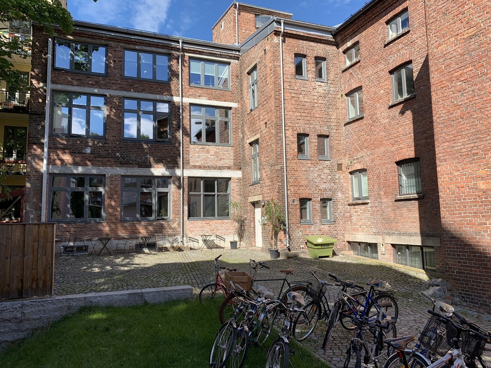 Hyggelig og forseggjort bakgård med felles sykkelparkering, diverse sittegrupper og beplantning Galleribilde