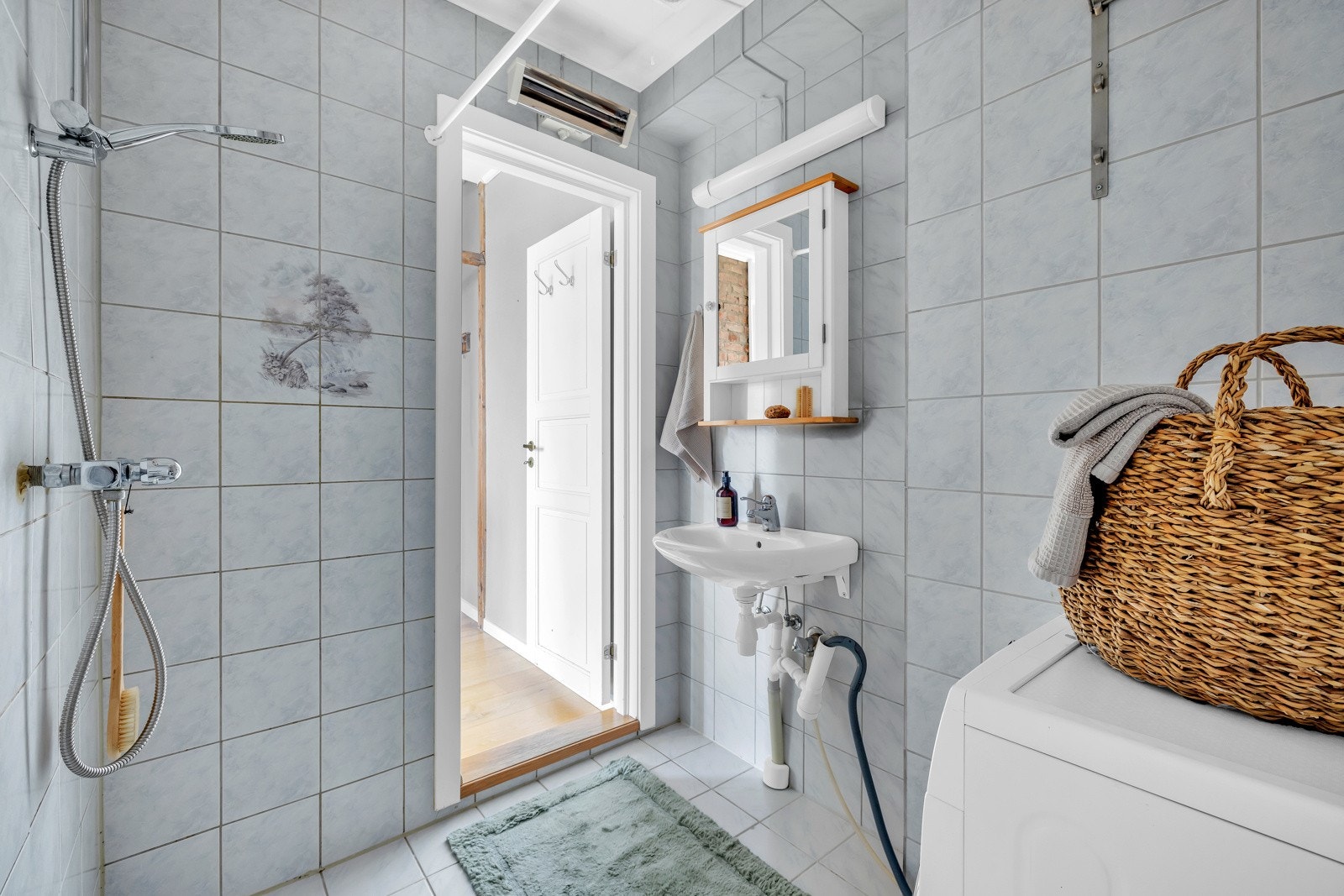 Badet inneholder servant med ett-greps blandebatteri., WC og dusjhjørne med forheng. Galleribilde