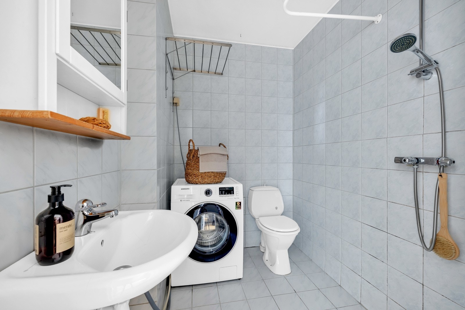 Romslig flislagt baderom med adkomst fra entréen. Opplegg for vaskemaskin. Galleribilde