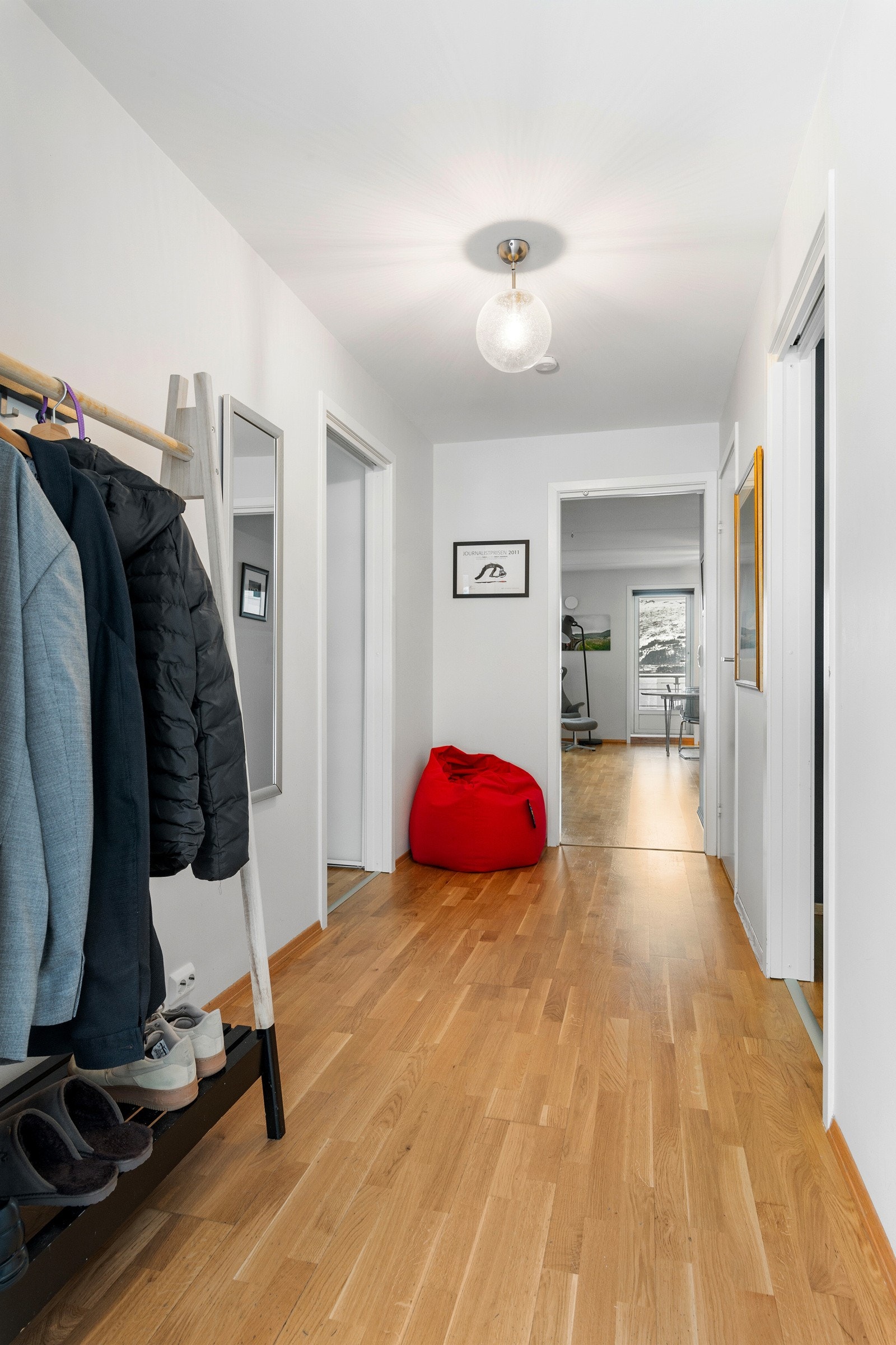 Velkommen inn. Gangen har som leiligheten ellers behagelige parkettgulv. Lyse farger og gjennomgående lys fra nord til sør. Galleribilde