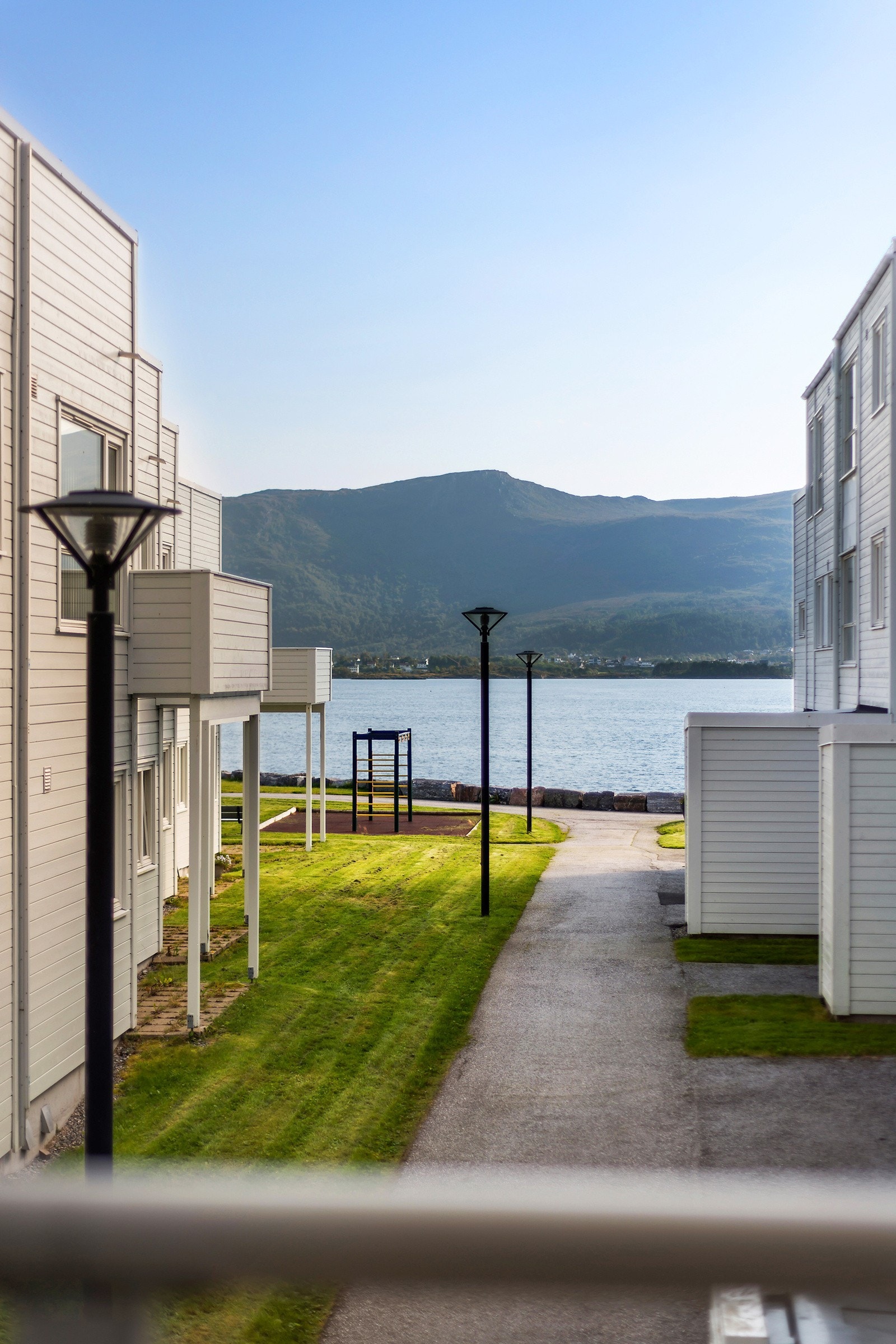 Fra leilighetens uteområde og stue er dette utsikten man kan nyte. Mellom rekkehusene ser man både havet og mot Sulafjellet. Galleribilde