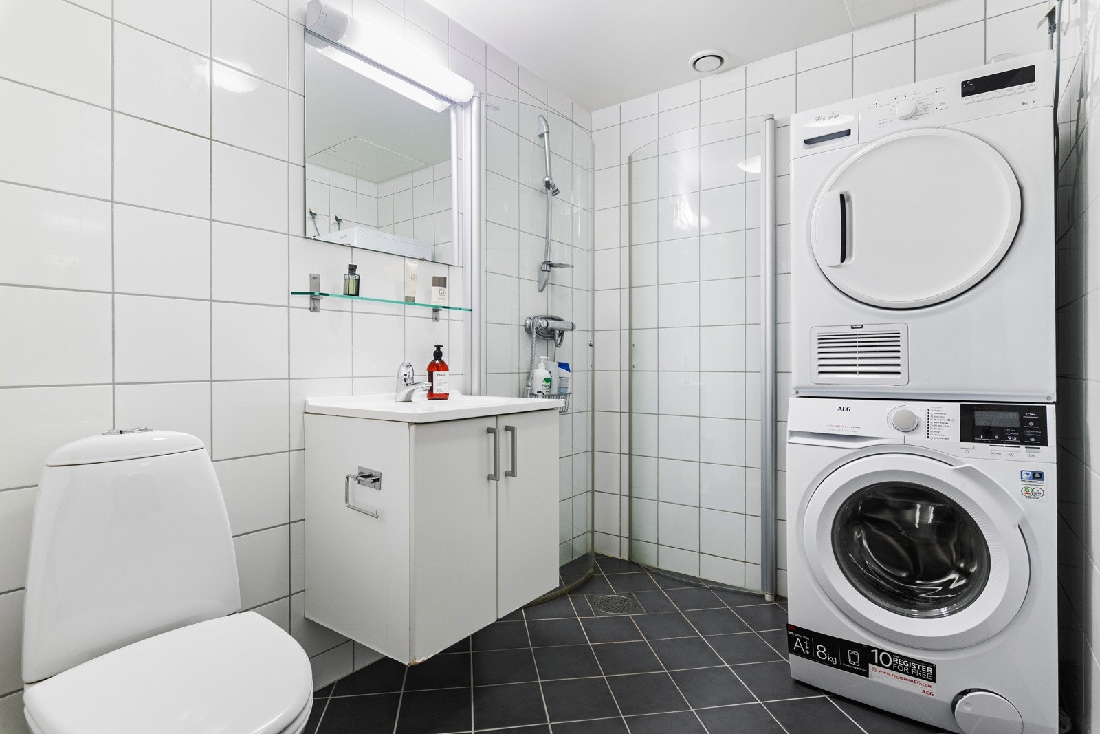 Badet er helfliset med varme i gulvet. Det er etablert dusjnisje med innfellbare vegger, opplegg for vaskemaskin og tørketrommel - Galleribilde