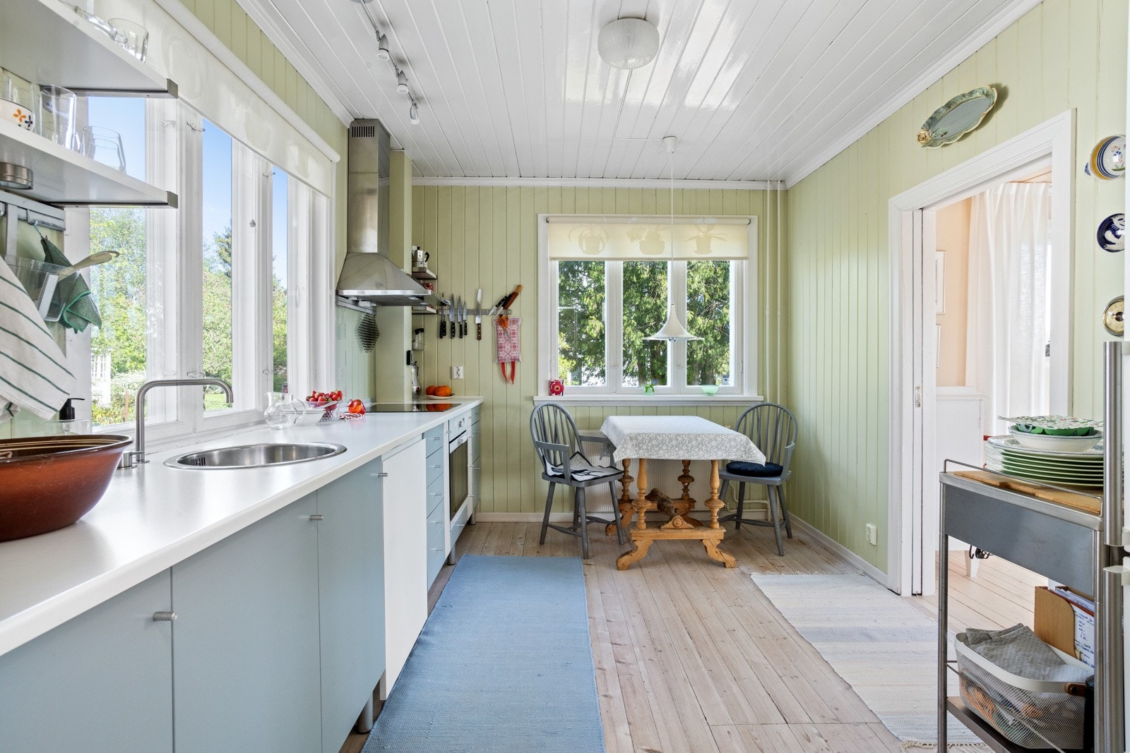 Kjøkkenet med flott innredning, inkludert malte fronter og laminat benkeplate med oppvaskkum Galleribilde