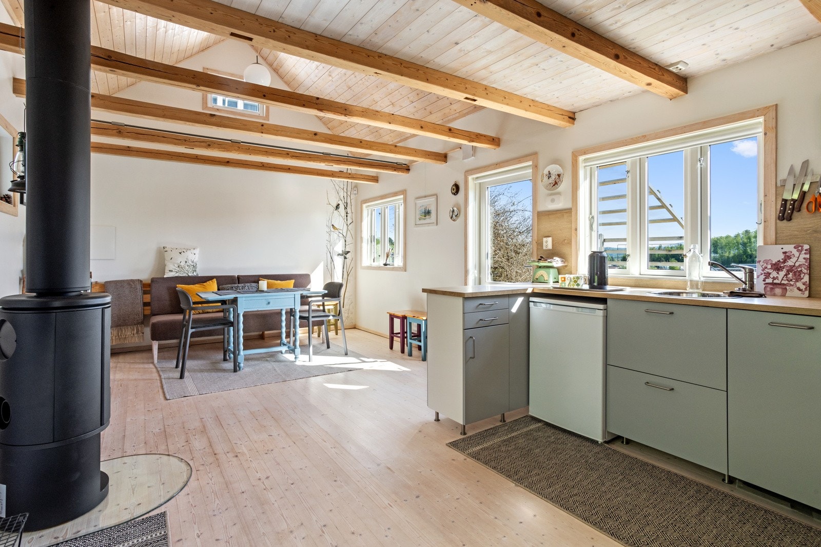 Annekset har en åpen kjøkken-stue løsning med de opprinnelige horisontale bjelkene i takkonstruksjonen Galleribilde