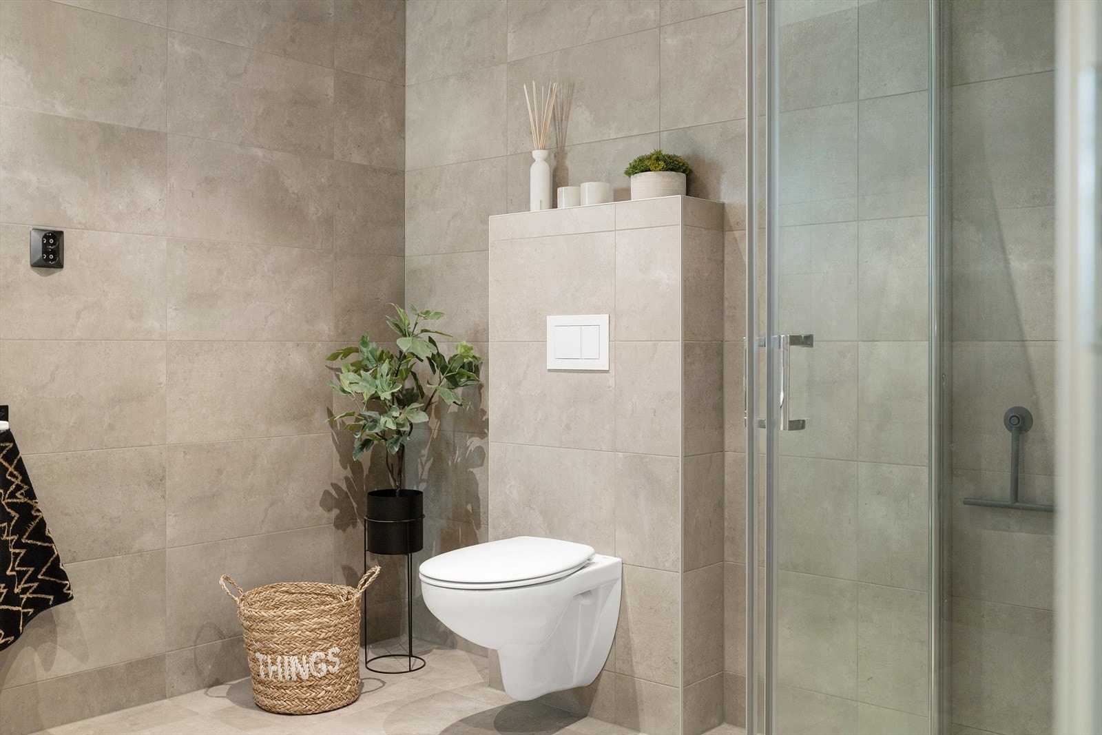 Badet er lekkert innredet med store fliser på både gulv og vegger. Galleribilde