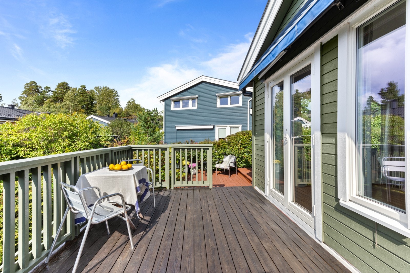 Stor terrasse som strekker seg langs to sider av boligen Galleribilde