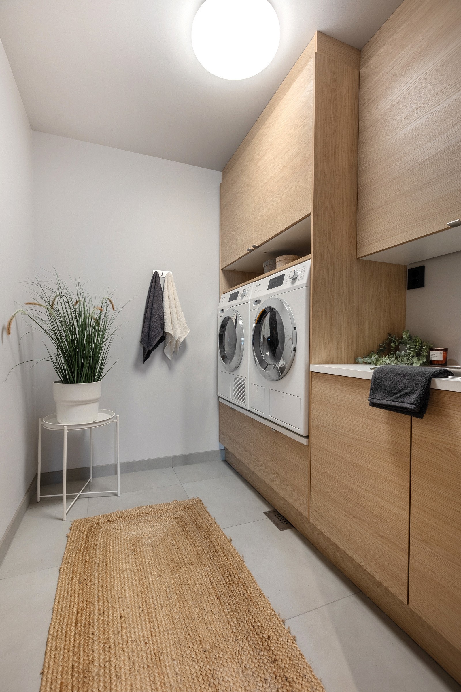 Et meget praktisk vaskerom, alt i arbeidshøyde, moderne innredning og vask nedfelt i benkeplate. Vaskemaskin og tørketrommel fra Miele, kan medfølge. Galleribilde