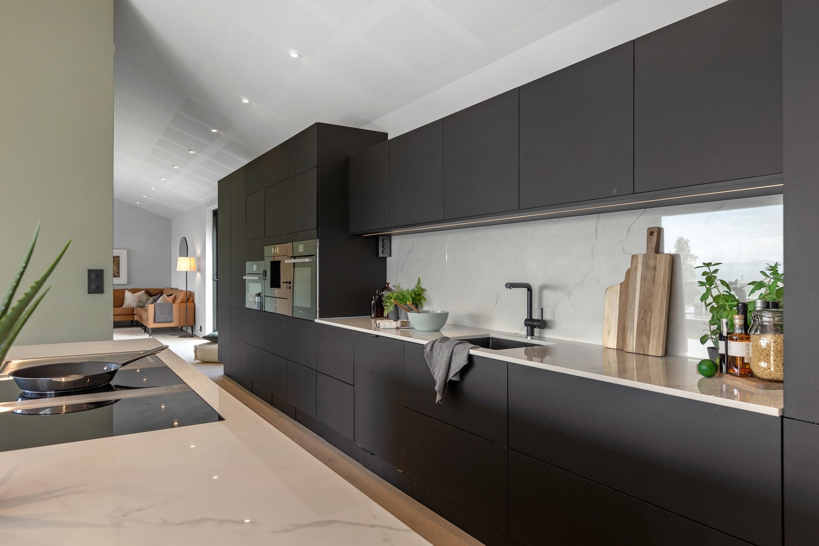 Kjøkkeninnredning på hele veggen, Dekton benkeplate. Et steinmateriale som skal tåle mye, feks sette fra seg varme kjeler Galleribilde