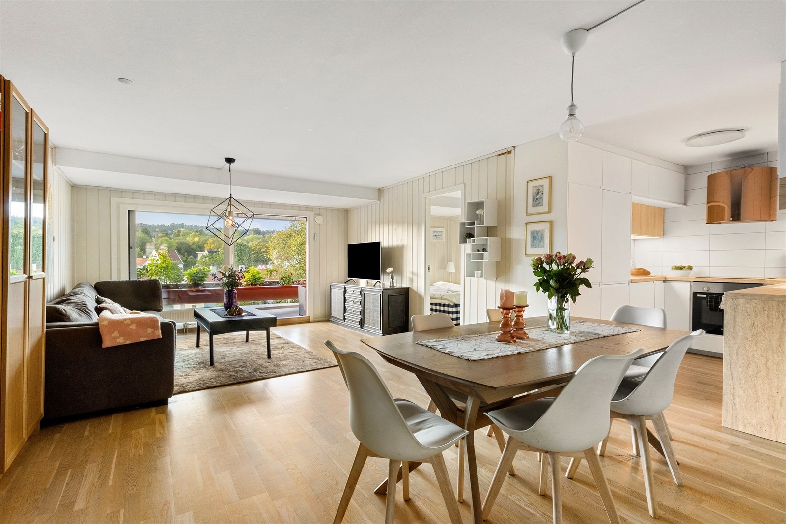 Delvis åpen kjøkkenløsning, tilbaketrukket fra sofagruppe. Galleribilde