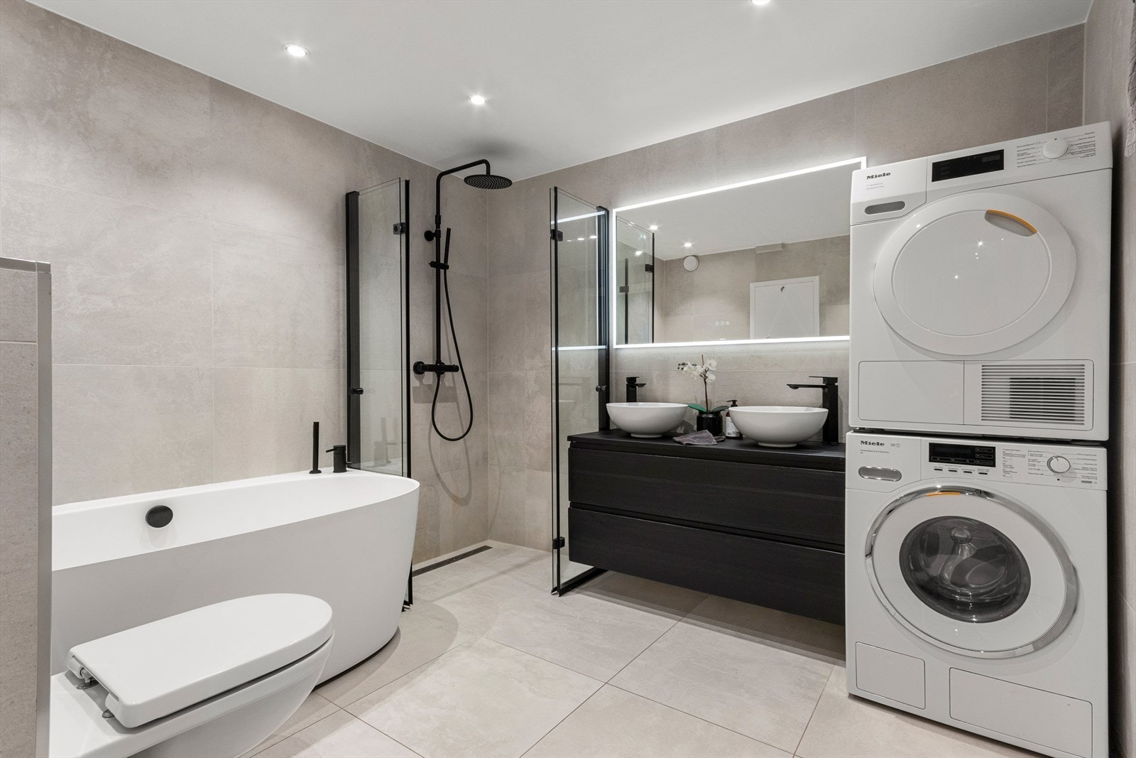 Delikat bad nytt i 2020 med badekar, hjørnedusj med regnfallarmatur, veggmontert klosett, dobbel servant med skuffer og speil med belysning Galleribilde