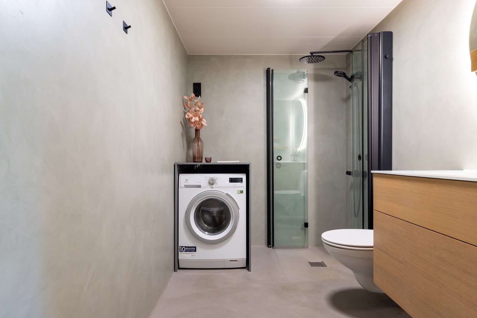 Det er opplegg for vaskemaskin i praktisk nisje, vegghengt toalett samt dusjhjørne med foldbare dører som frigjør plass på gulvet. Galleribilde