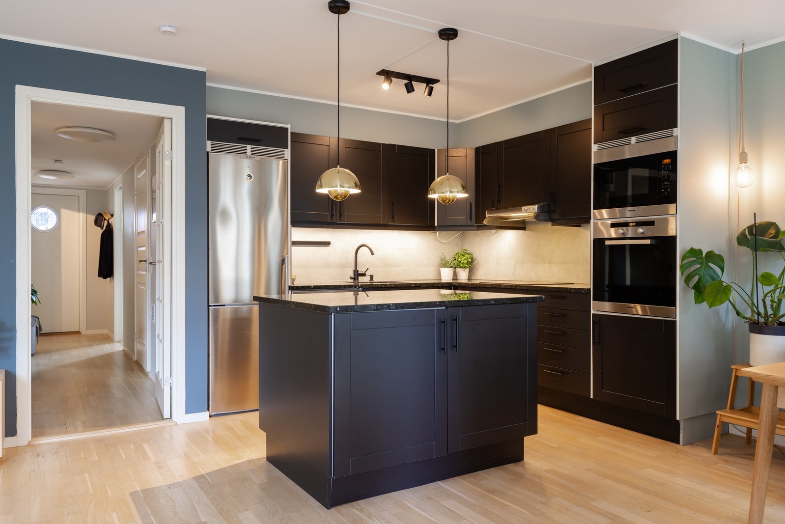 Boligen har et pent kjøkkenhjørne fra 2018 med profilert, mørk innredning, stein benkeplate og vaskekum med ett-greps blandebatteri. Under overskapene er det montert lys og stikkontakter. Galleribilde