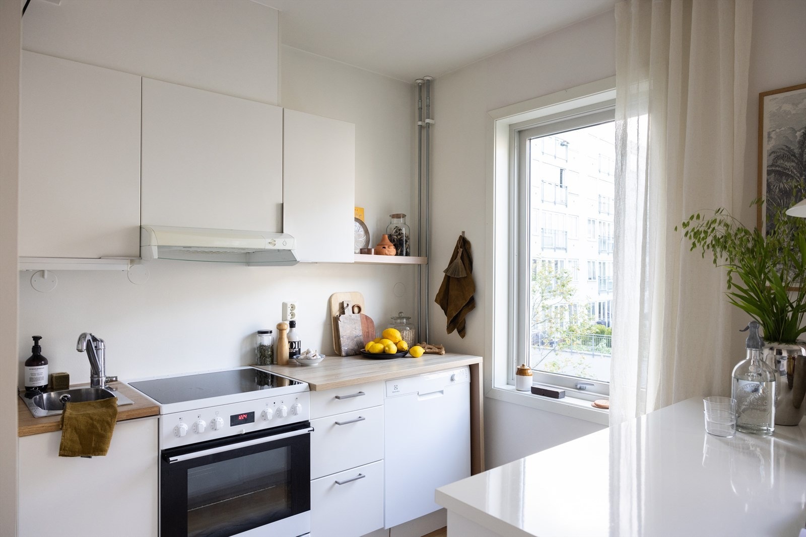 - Kjøkkeninnredning med glatte fronter. Laminat benkeplate med nedfelt vask- og skyllekum. Avtrekk over kokeplass - Galleribilde