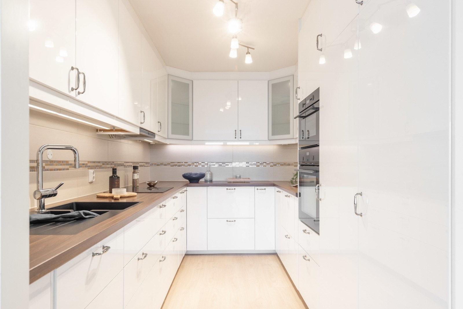 Kjøkkeninnredning fra IKEA fremstår lys og moderne med fronter i høyglans og to vitrineskap. Galleribilde