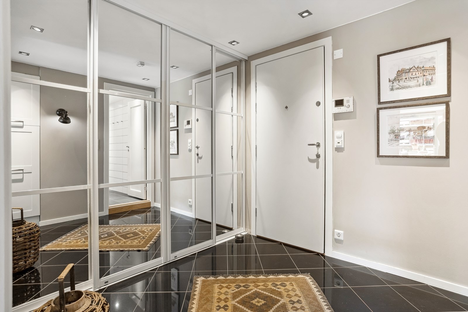 Her ønskes du velkommen inn til en romslig og flislagt entré. Det god plass for oppheng av yttertøy i en stor og meget dyp skyvedørsgarderobe med speilfronter. Galleribilde