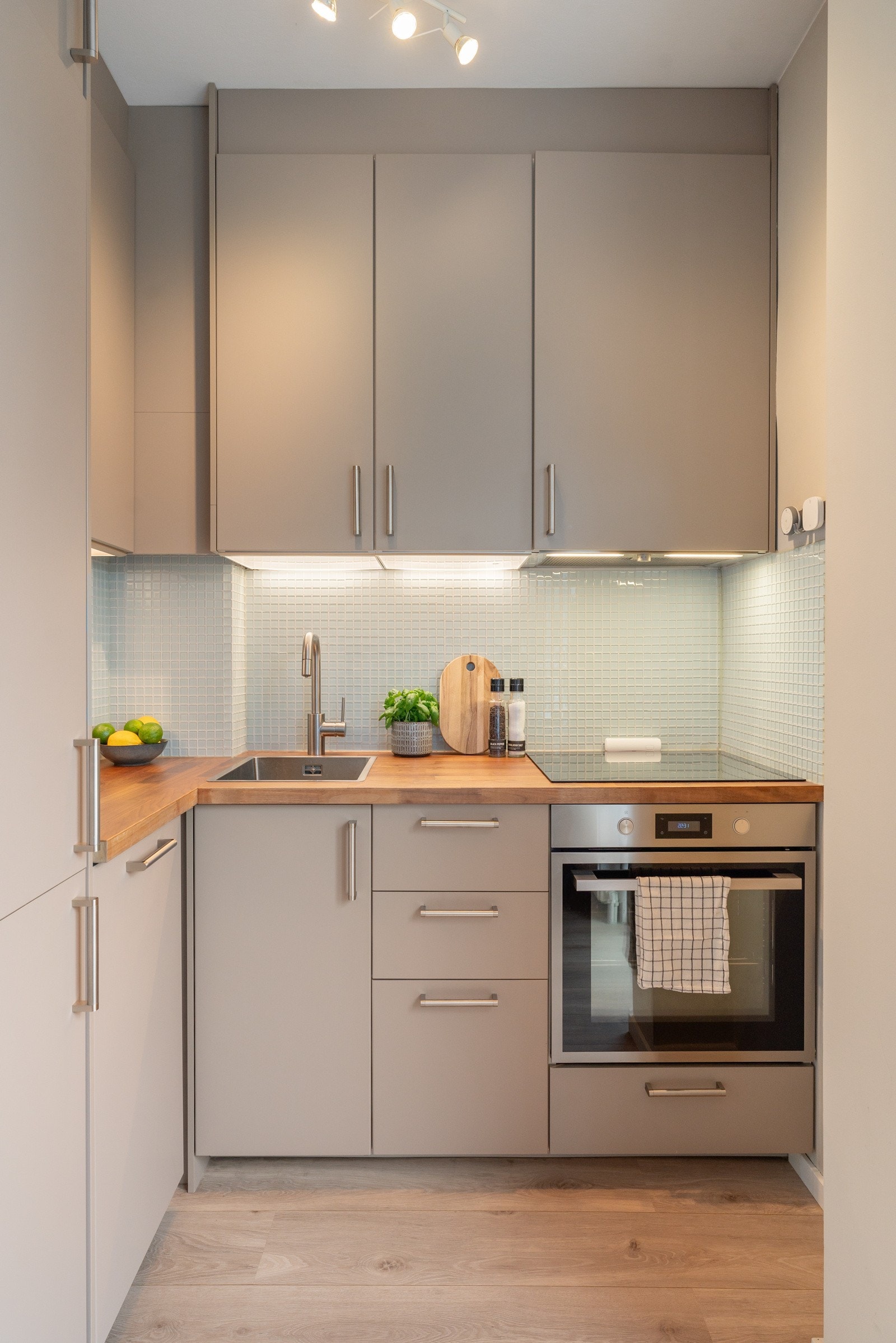 Lekkert og moderne kjøkken som består av glatte fronter og benkeplate i heltre. Galleribilde