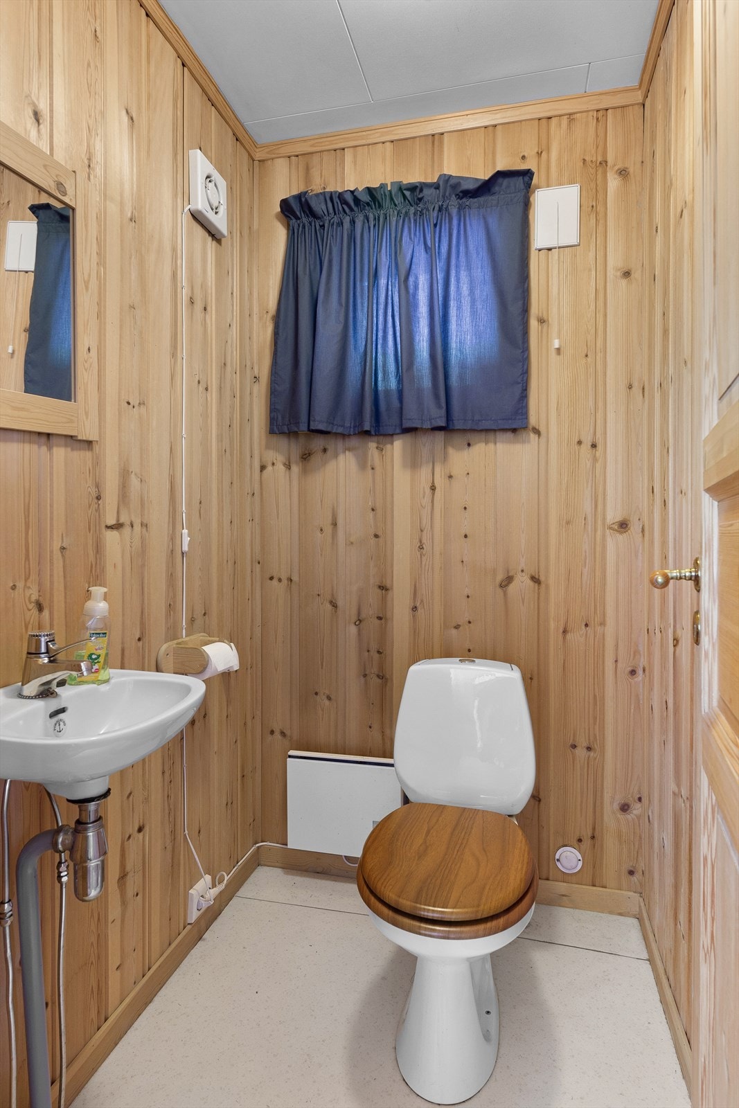 Toalettrom i underetasjen med enkel servant og toalett. Galleribilde