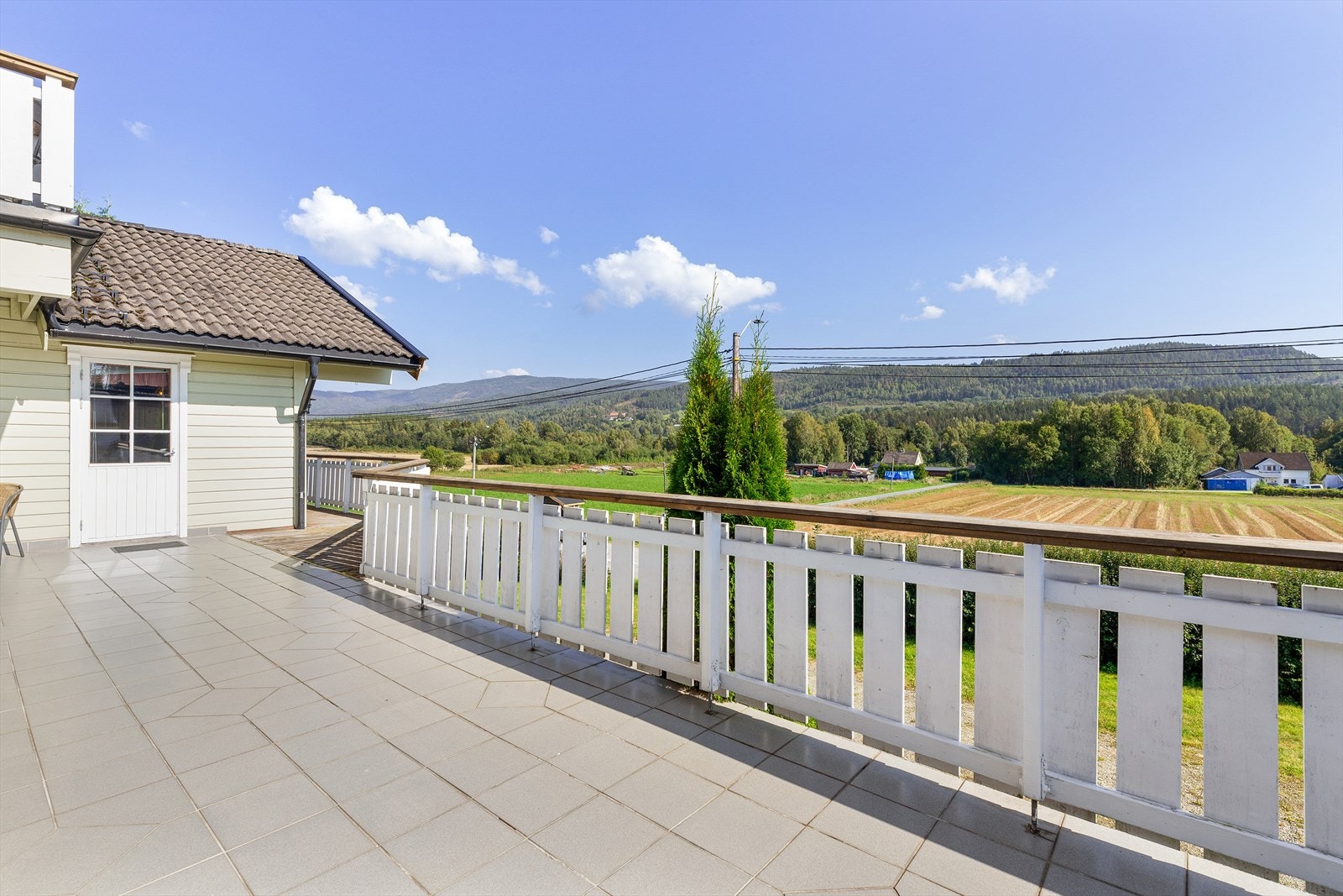 Flislagt og romslig terrasse med utsikt utover det naturskjønne landskapet. Galleribilde