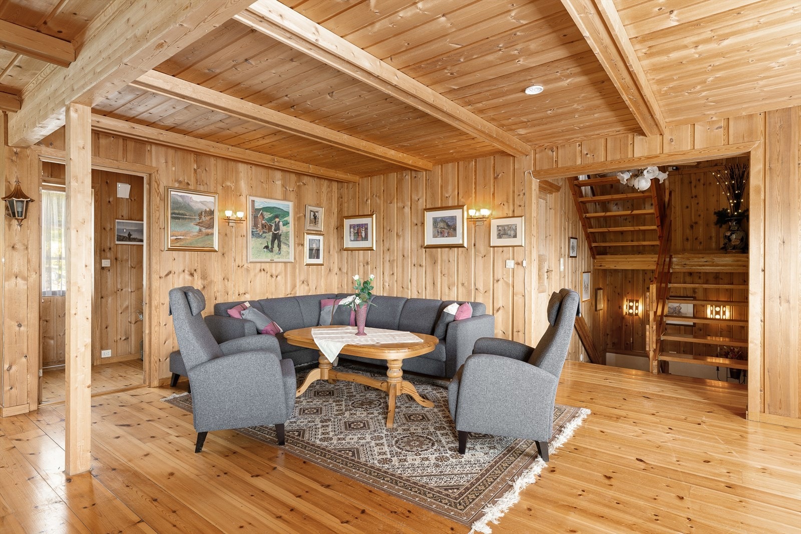 Stuen har furugulv og furu trepanel på vegg. Galleribilde