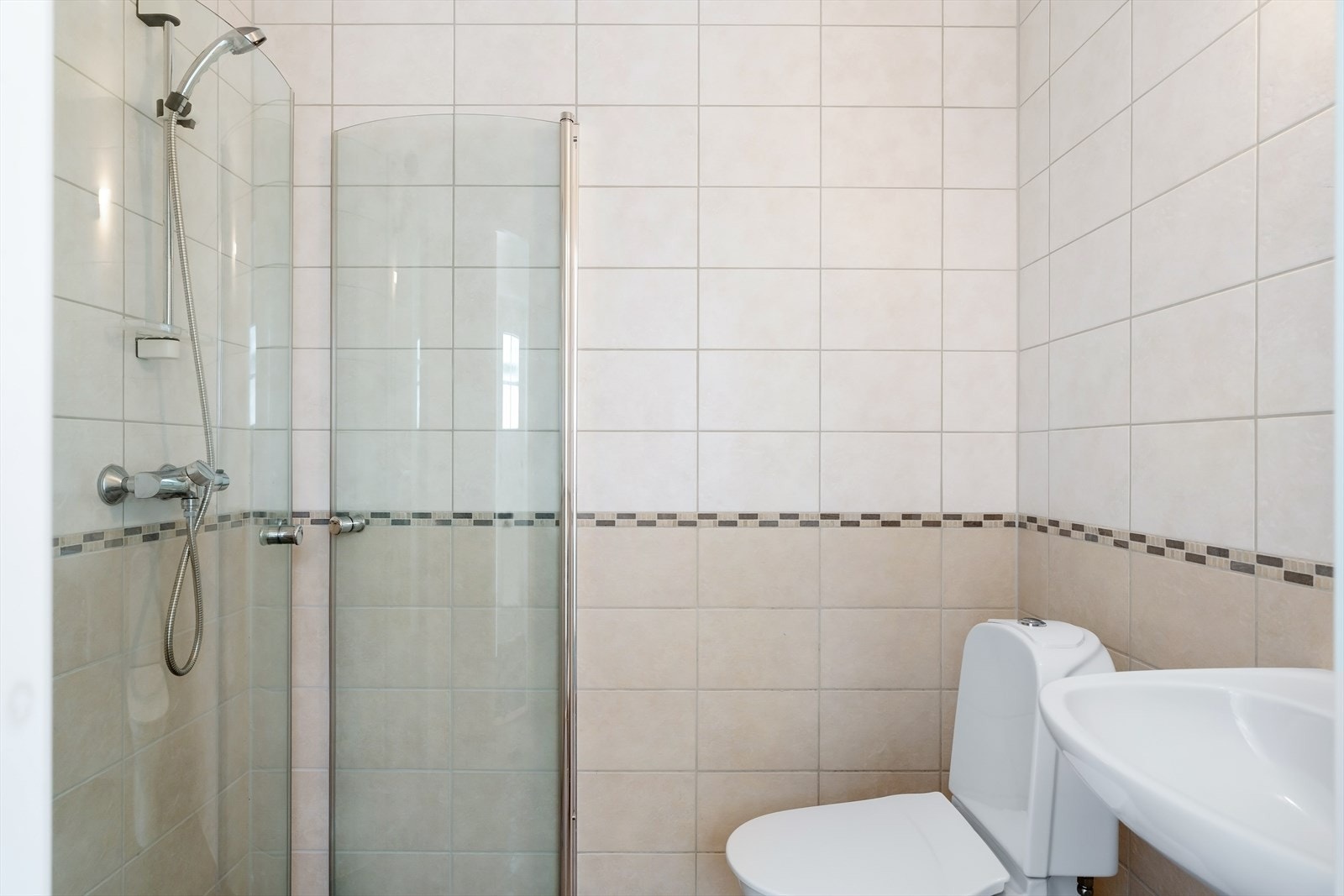 Baderom i undertasjen med dusj, toalett og vask. Galleribilde