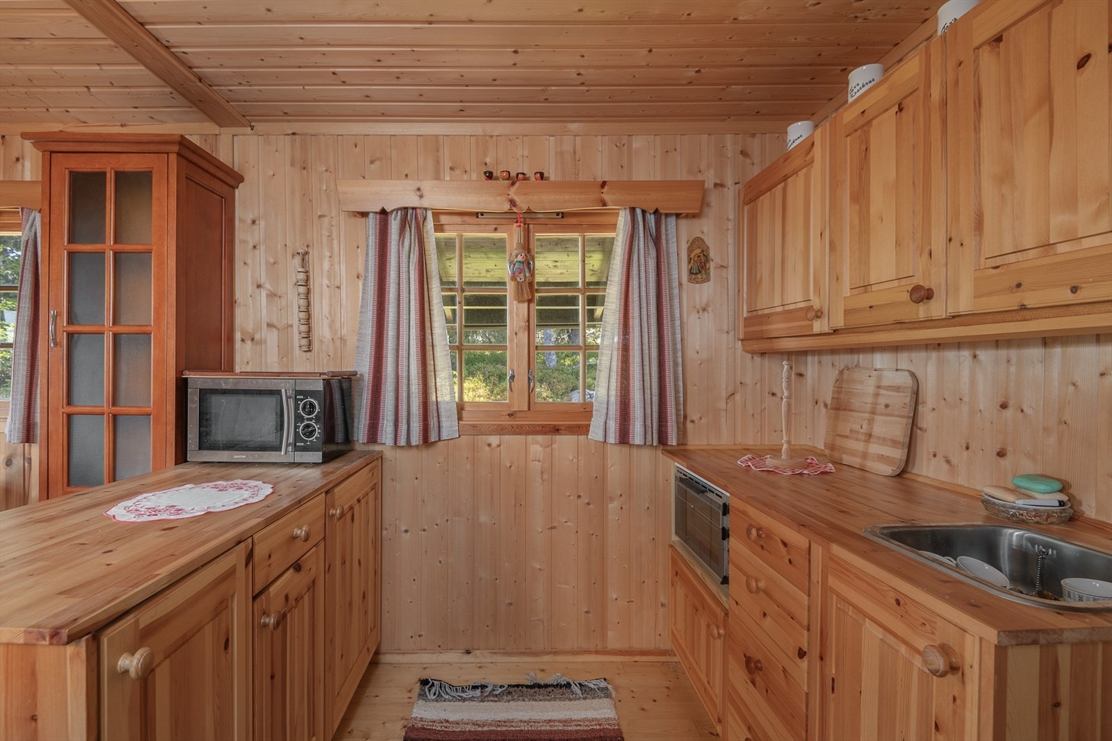 Det er over-og underskap for oppbevaring på kjøkkenet. Et lite vindu slipper inn fint lys. Galleribilde