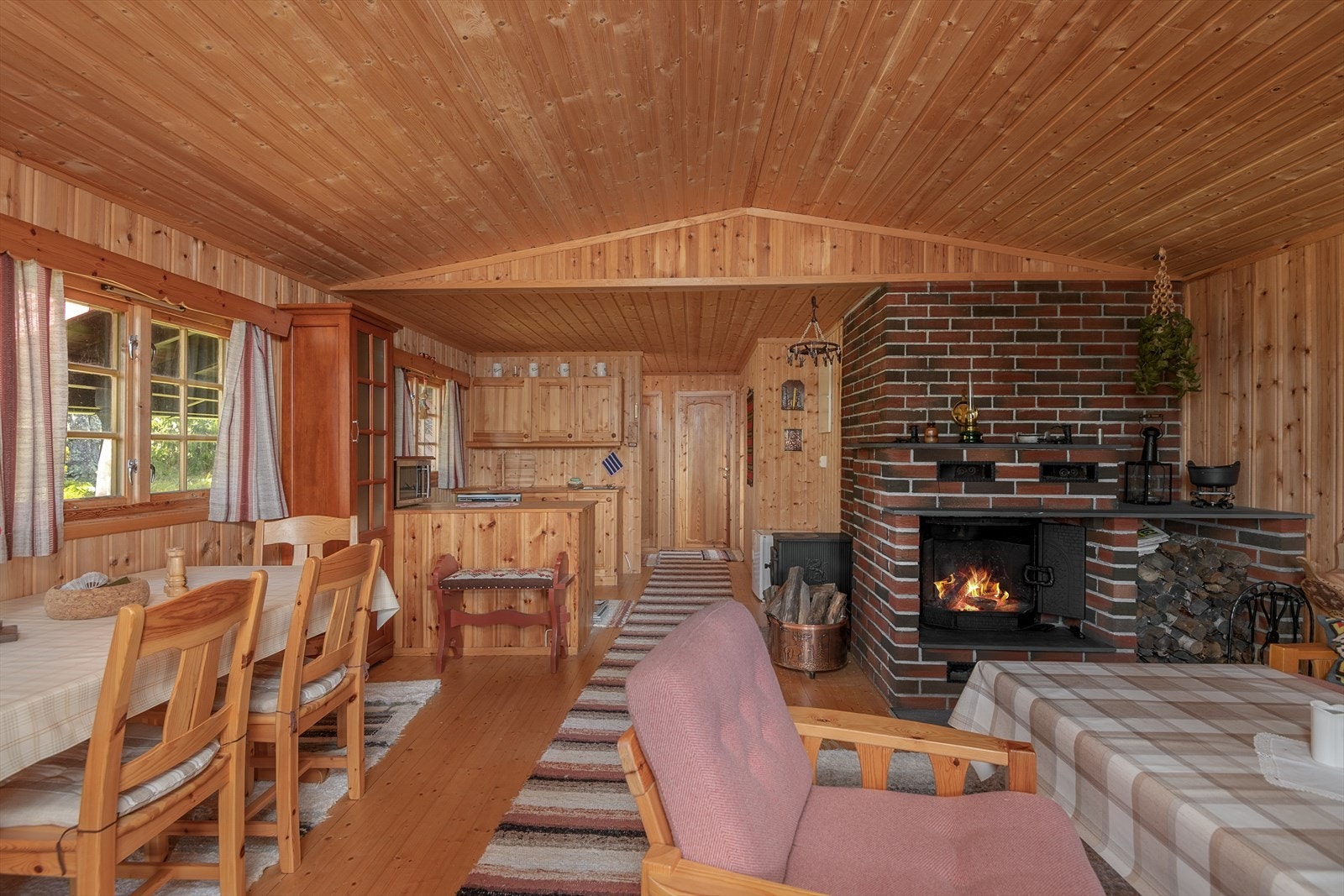 Det er en åpen løsning mellom kjøkken og stua, noe som gir et sosialt og hyggelig oppholdsrom. Galleribilde