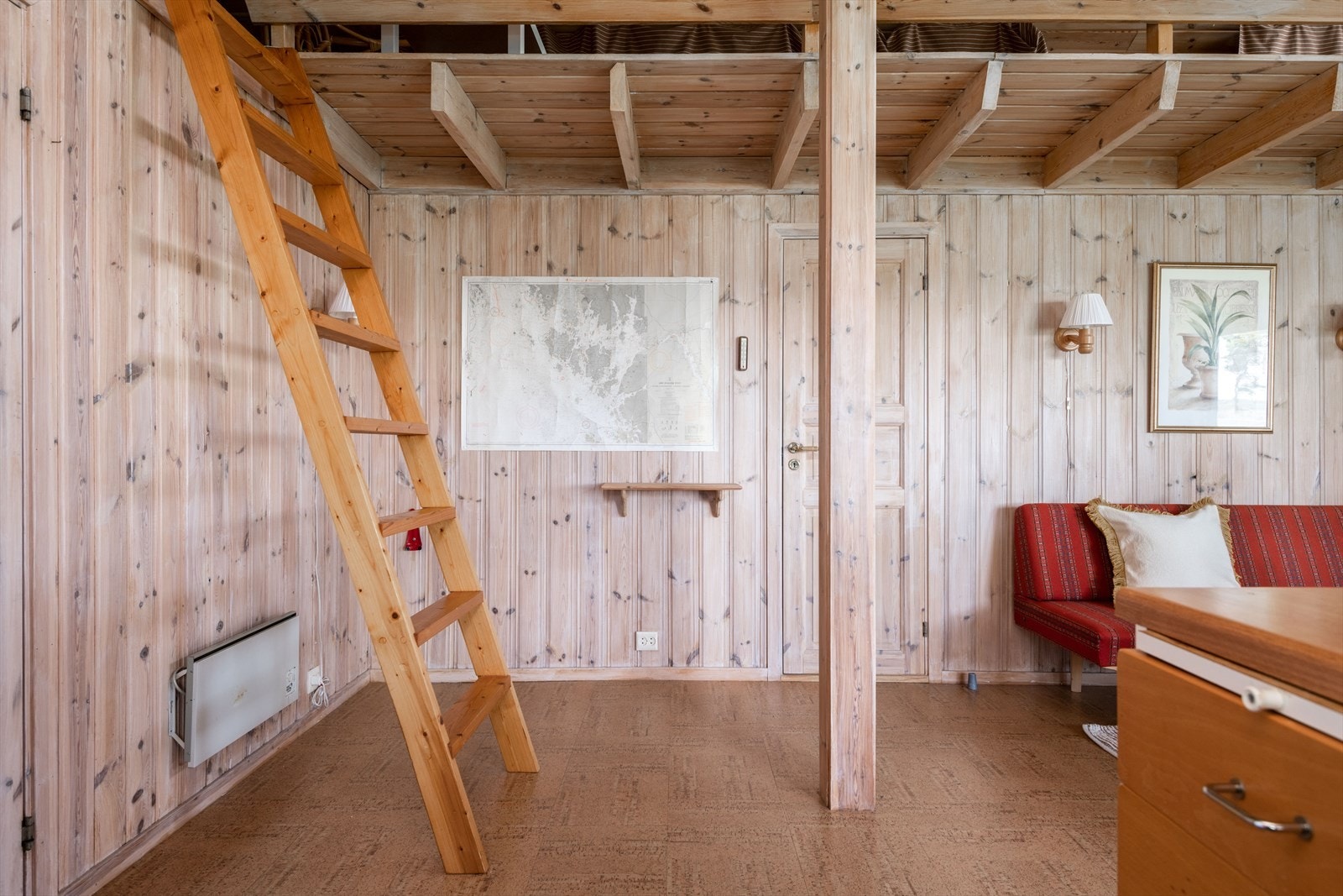 En trapp/stige fører opp til en hems med lav takhøyde - et perfekt sted å klargjøre til overnattingsgjester eller bruke som et koselig lesehjørne. Galleribilde
