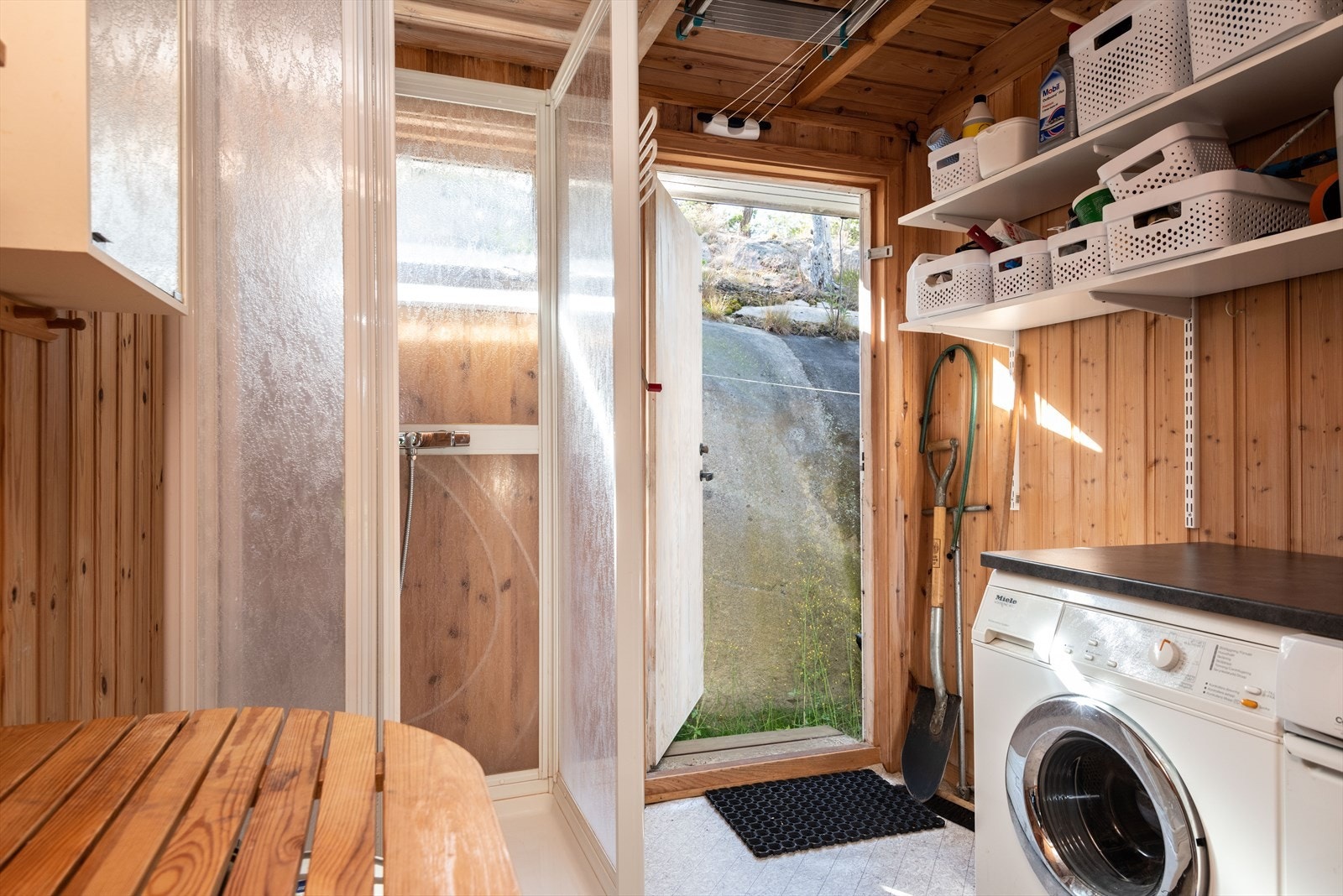 Fra dusjrommet er det utgang til baksiden av hytta hvor en enkel platting gir en perfekt plass til å henge klesvask til tørk. Galleribilde