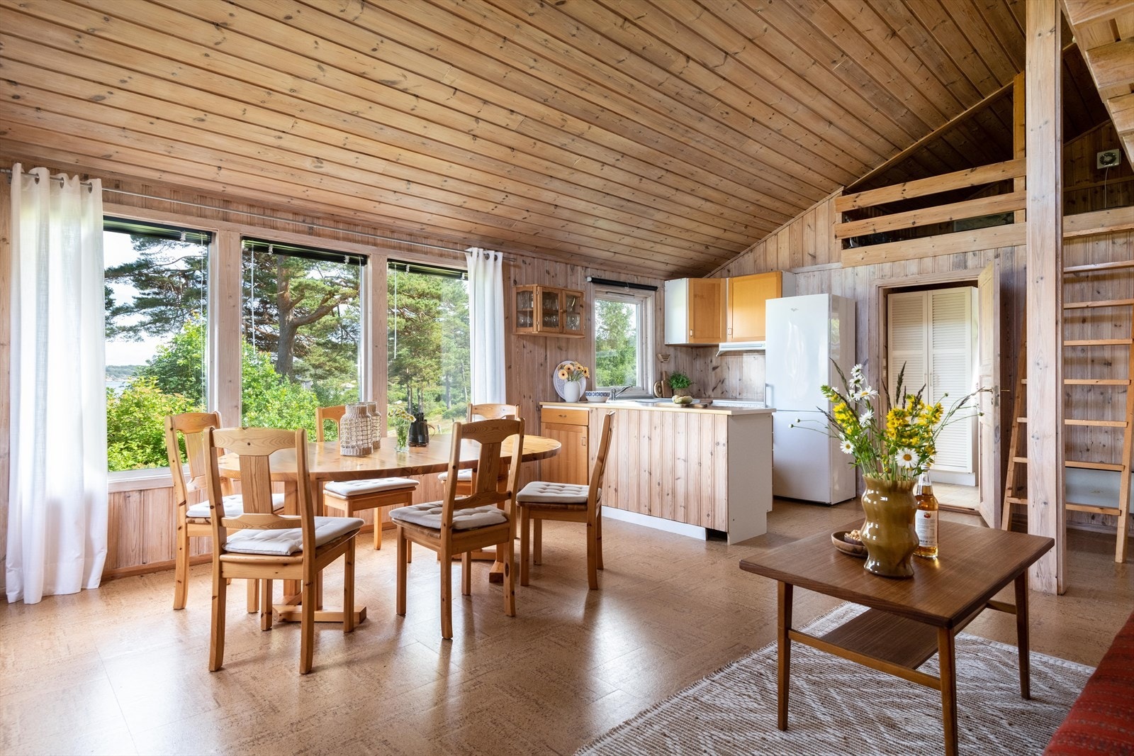 Det er en åpen løsning mellom stue og kjøkken, og her er det åpen himling som gir en god romfølelse. Galleribilde