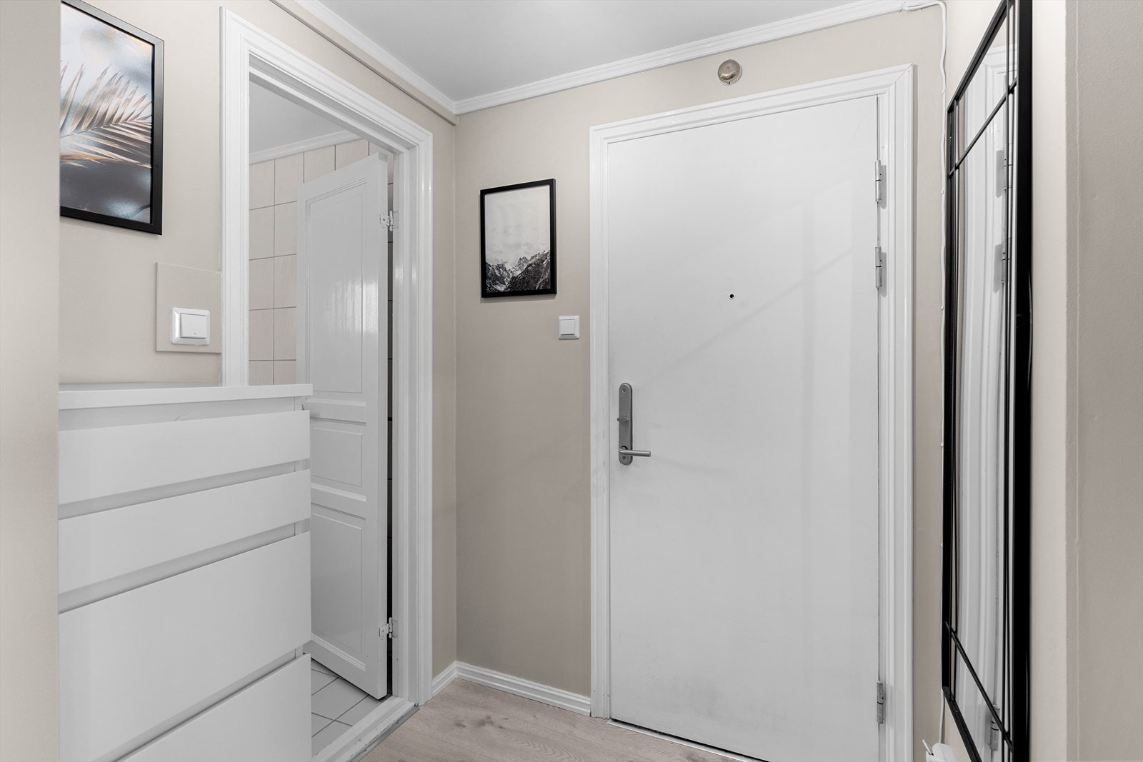 Lys og innbydende entré med gode muligheter for oppbevaring av yttertøy i innhuk med garderobehyller og annet møblement. Galleribilde