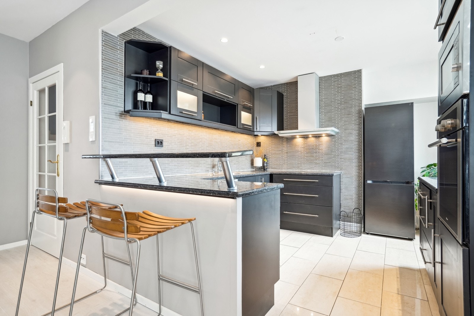 Kjøkkenet har rikelig med skap- og benkeplass, og er tilpasset med en perfekt løsning for barstoler ved siden av. Galleribilde