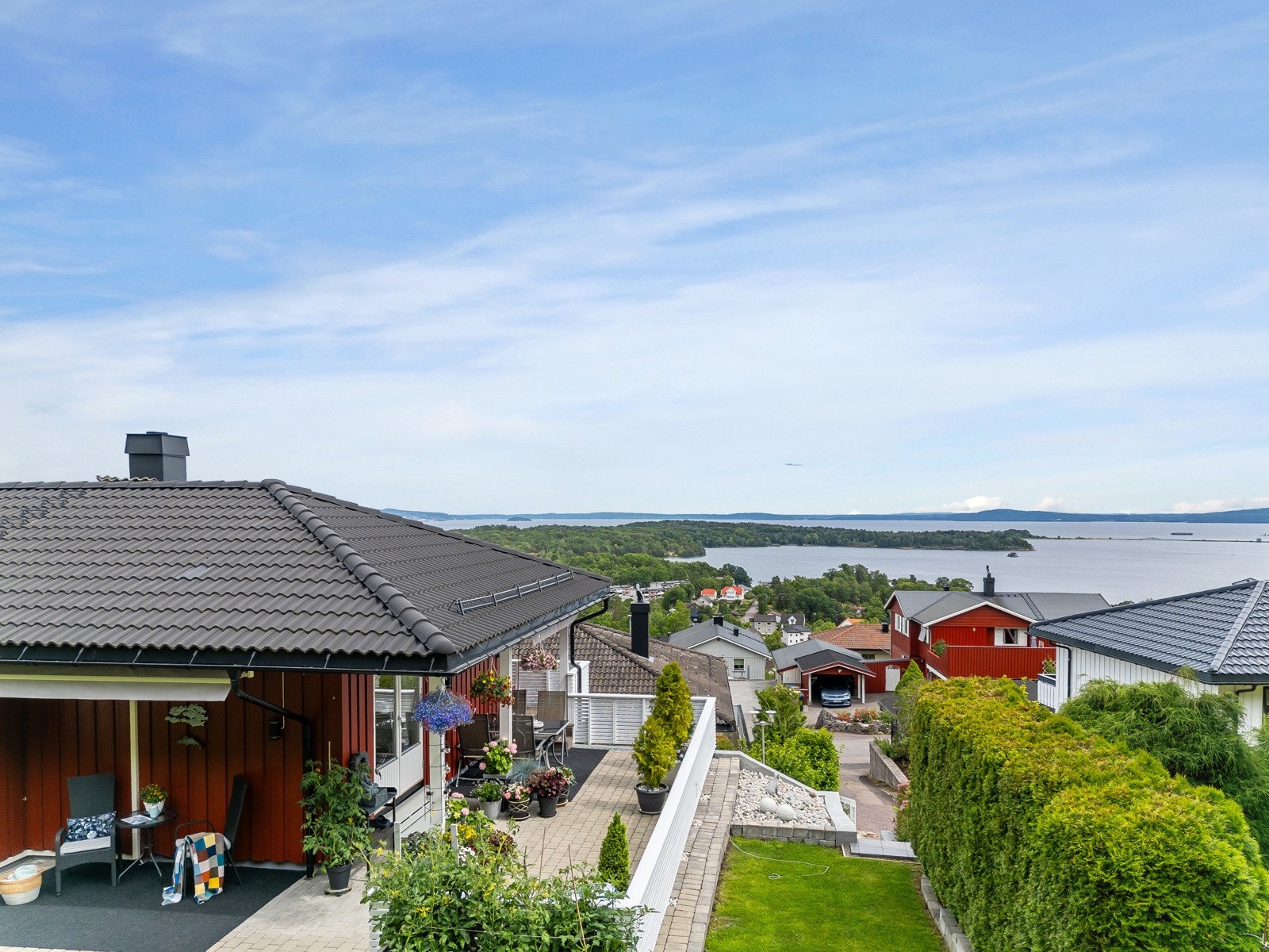 Stor steinlagt veranda, delvis overbygd og med terrassemarkiser. Galleribilde