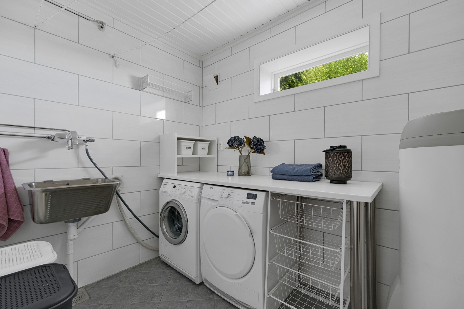 Pent vaskerom med fliser og varmekabler, rommet ble pusset opp i 2018. Det er innredet med praktisk vaskerom og opplegg for både vaskemaskin og tørketrommel. Galleribilde