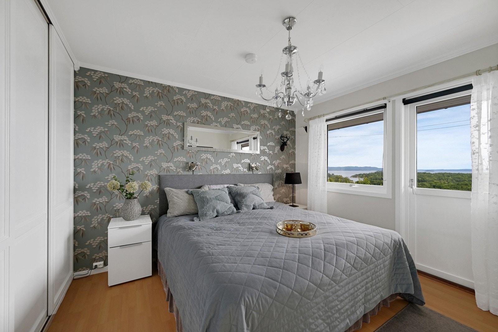 Hovedsoverom med pen dekorert vegg og laminat på gulvet. Galleribilde