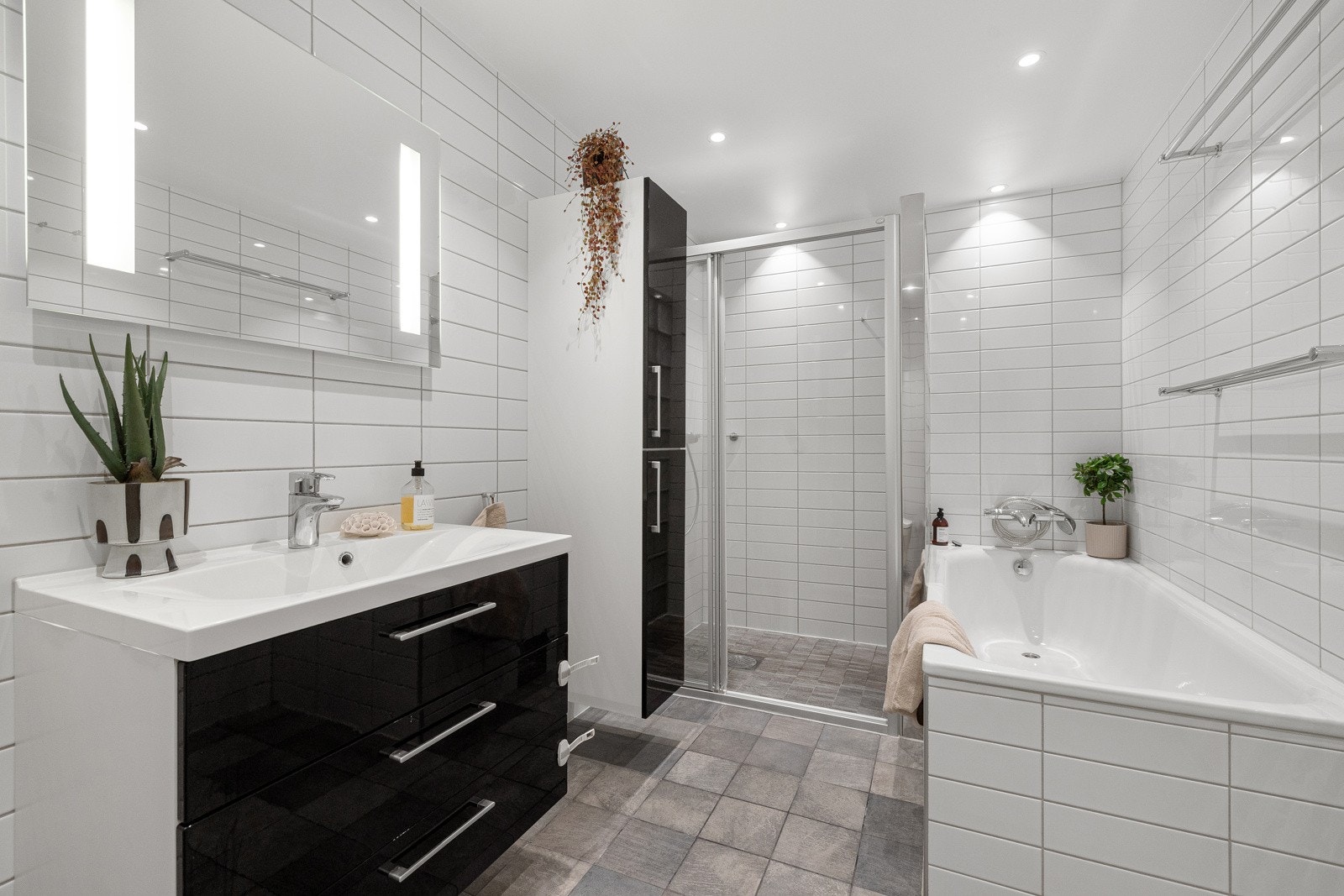 Et pent og praktisk bad med både badekar og dusjnisje, samt oppbevaringsplass i både servant- og høyskap. Galleribilde