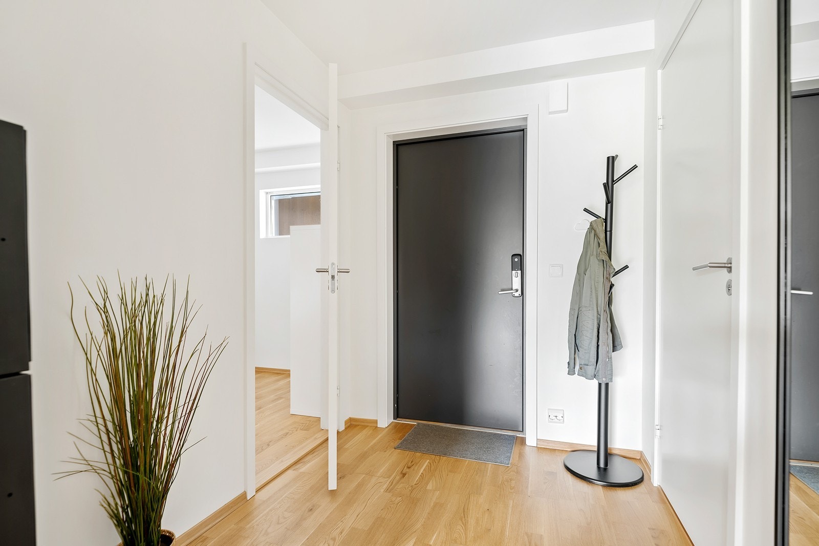 Lys og innbydende entré med moderne detaljer og parkettgulv. Galleribilde