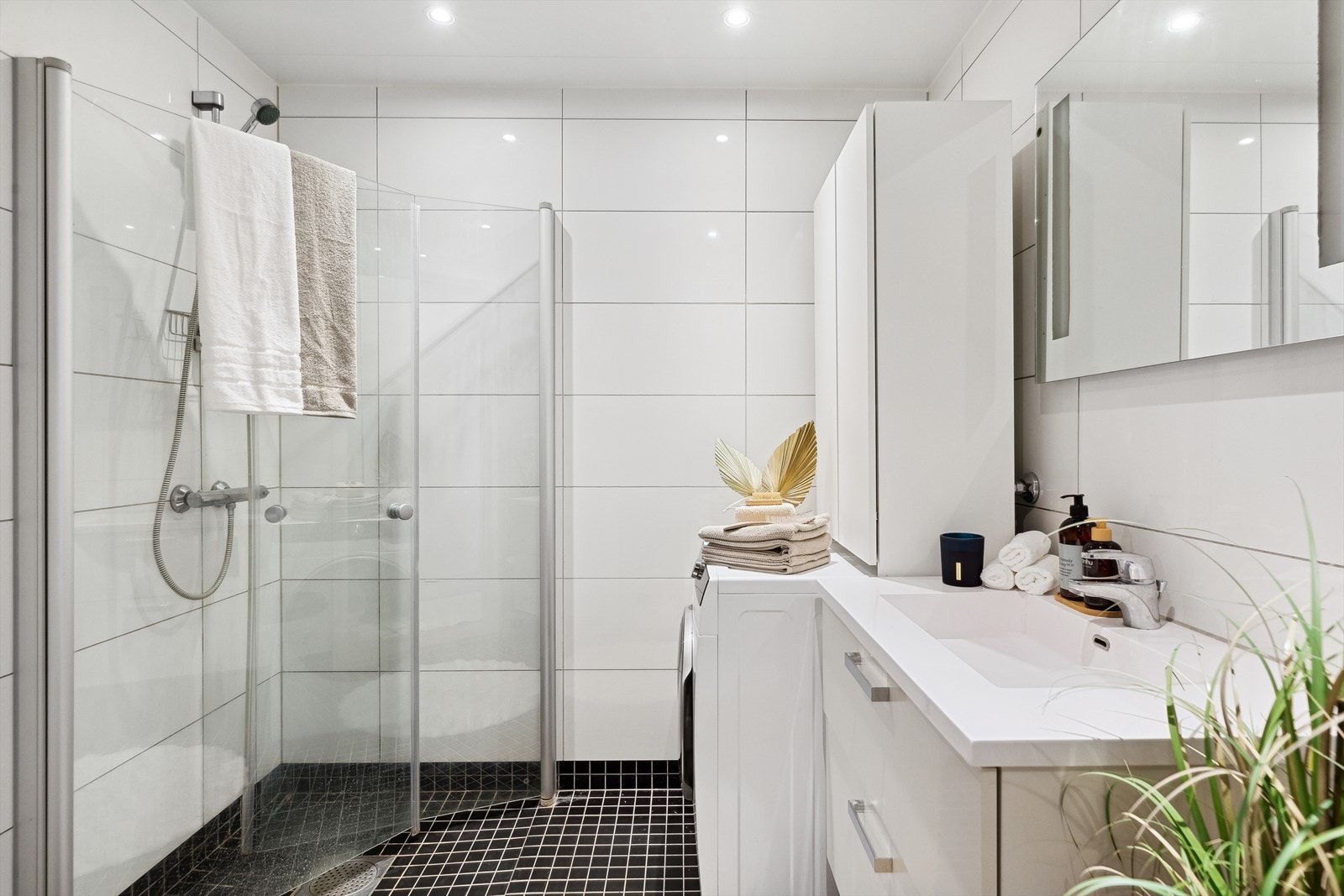 Badet er delikat med mørke gulvfliser, lyse veggfliser og downlights. Galleribilde