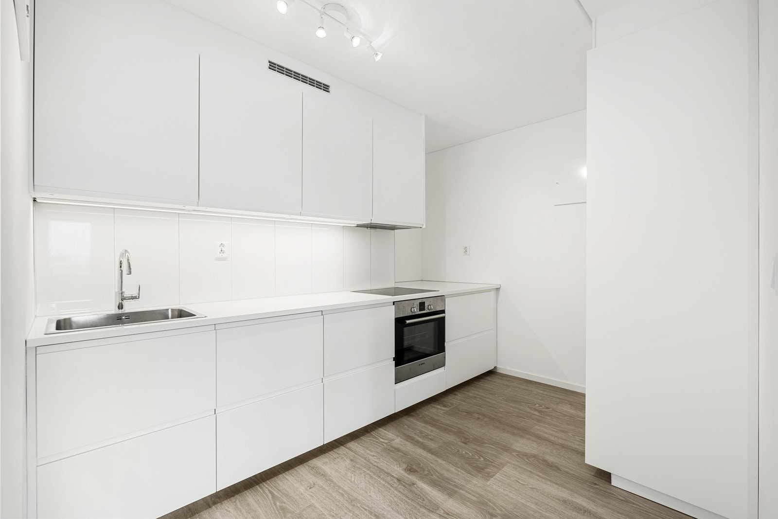 Kjøkkenet er oppgradert i 2024 og har innredning med glatte fronter og benkeplate av laminat, samt mye plass i skuffer og skap. Galleribilde