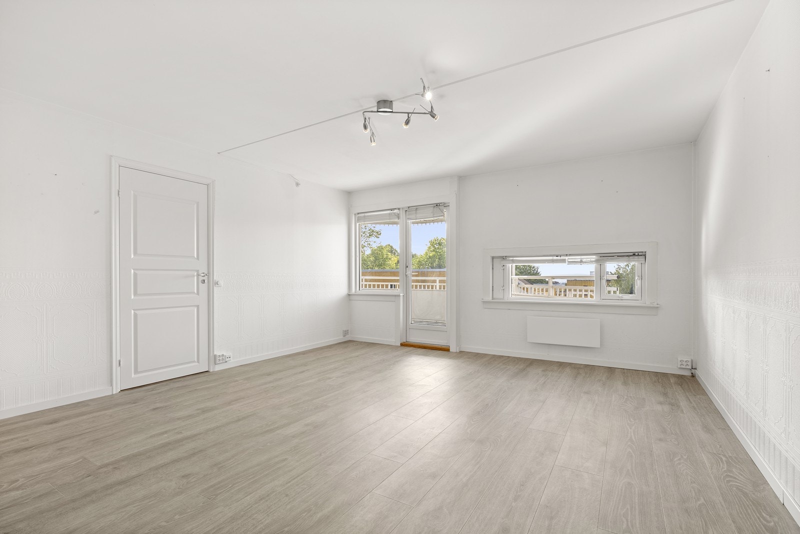 Leiligheten oppleves lys og romslig med hvitmalte vegger og laminatgulv Galleribilde
