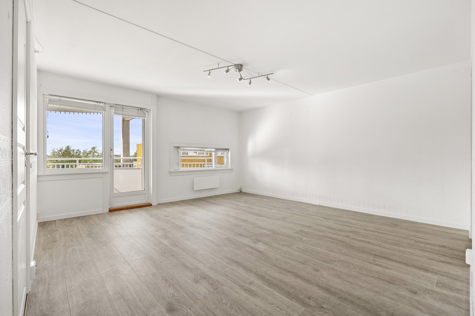 Romslig stue med flere møbleringsalternativer. Det er utgang til balkong fra stuen. Galleribilde