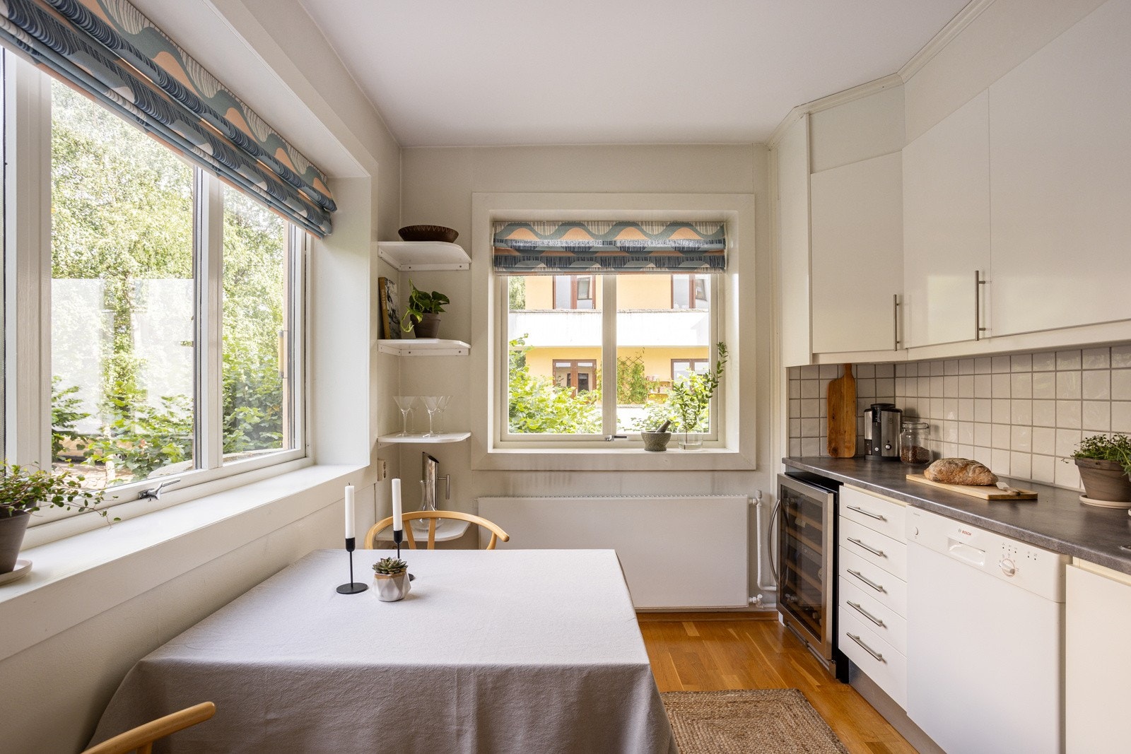 Kjøkkeninnredning fra 2011 med hvite glatte fronter og benkeplate av laminat og stein. Nedsenket oppvaskkum med ett-greps armatur. Galleribilde