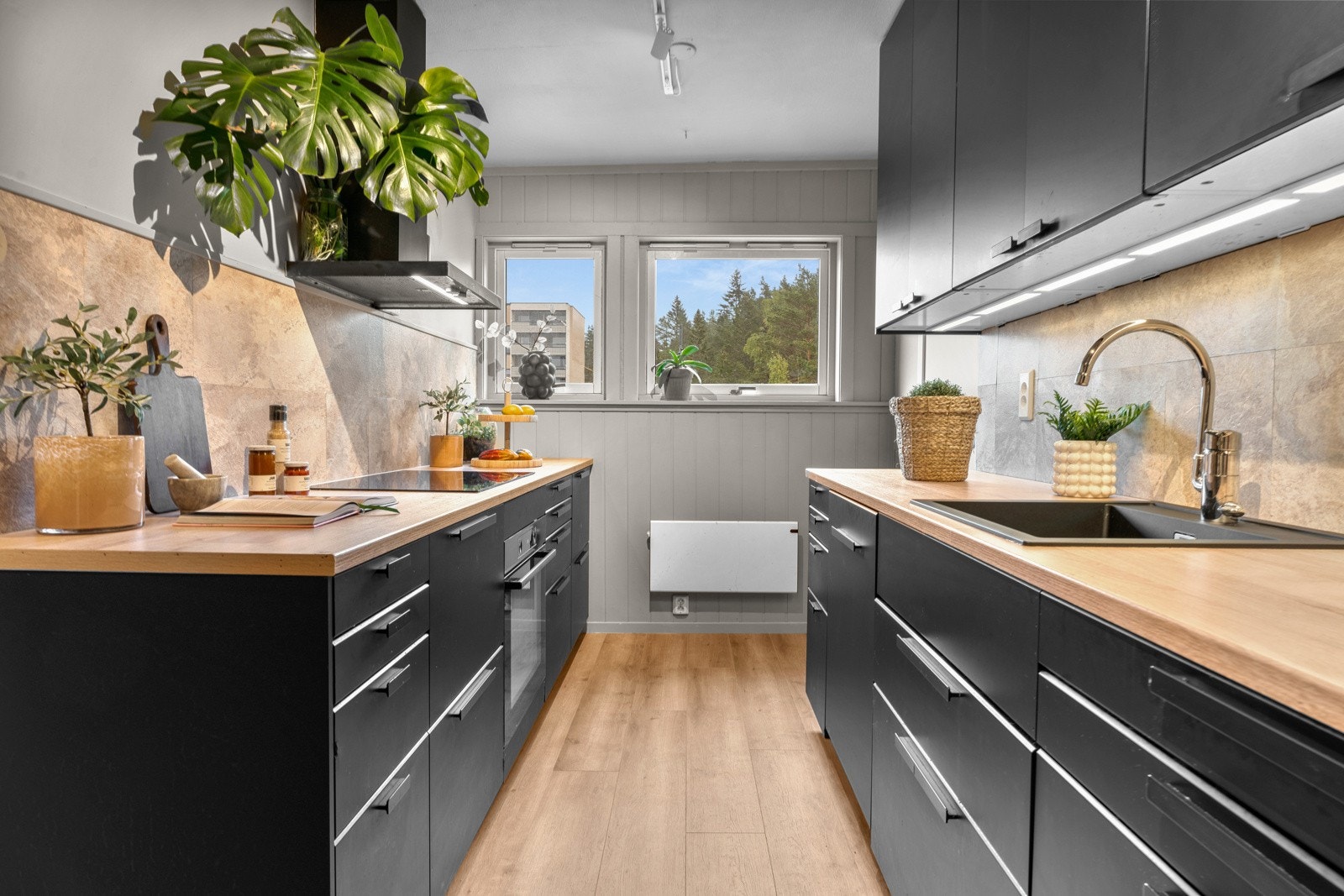 Integrerte hvitevarer som induksjonsplatetoppen, stekeovnen, oppvaskmaskinen og kjøle-/fryseskapet følger leiligheten. Galleribilde