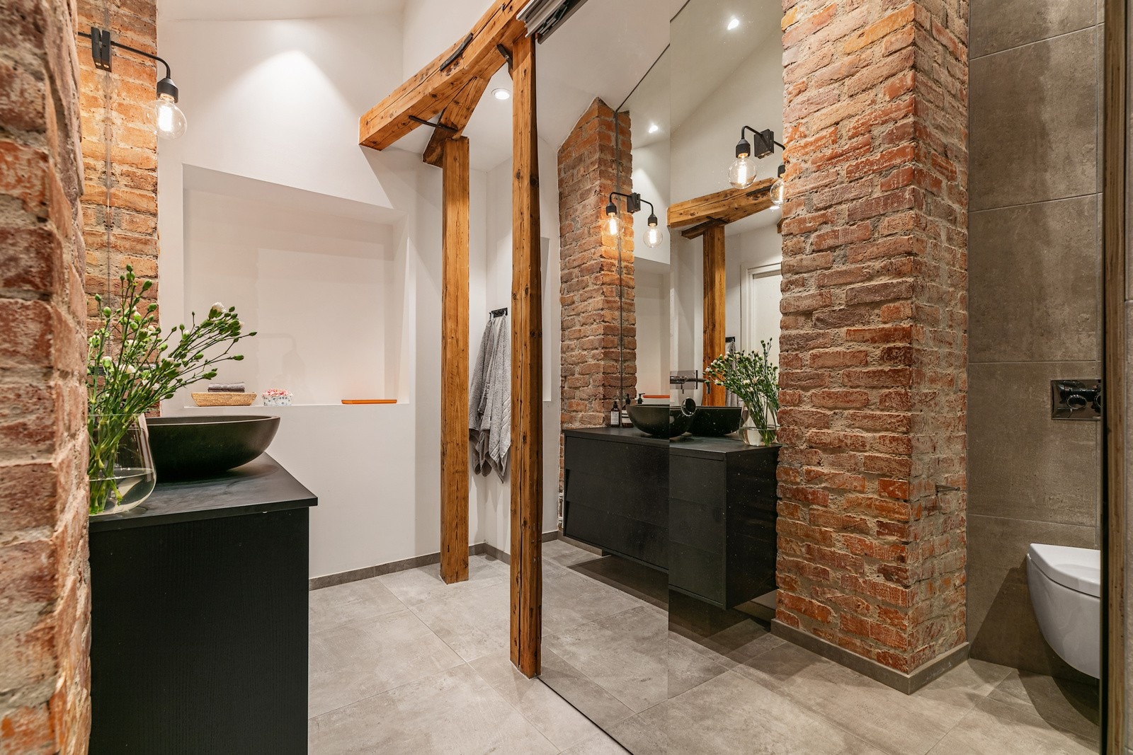 Badet har et særegent uttrykk med teglsteinsvegger og trebjelker, og byr også på en generøs takhøyde på ca. 3.60 m. på det høyeste. Det er downlights i himling. Galleribilde